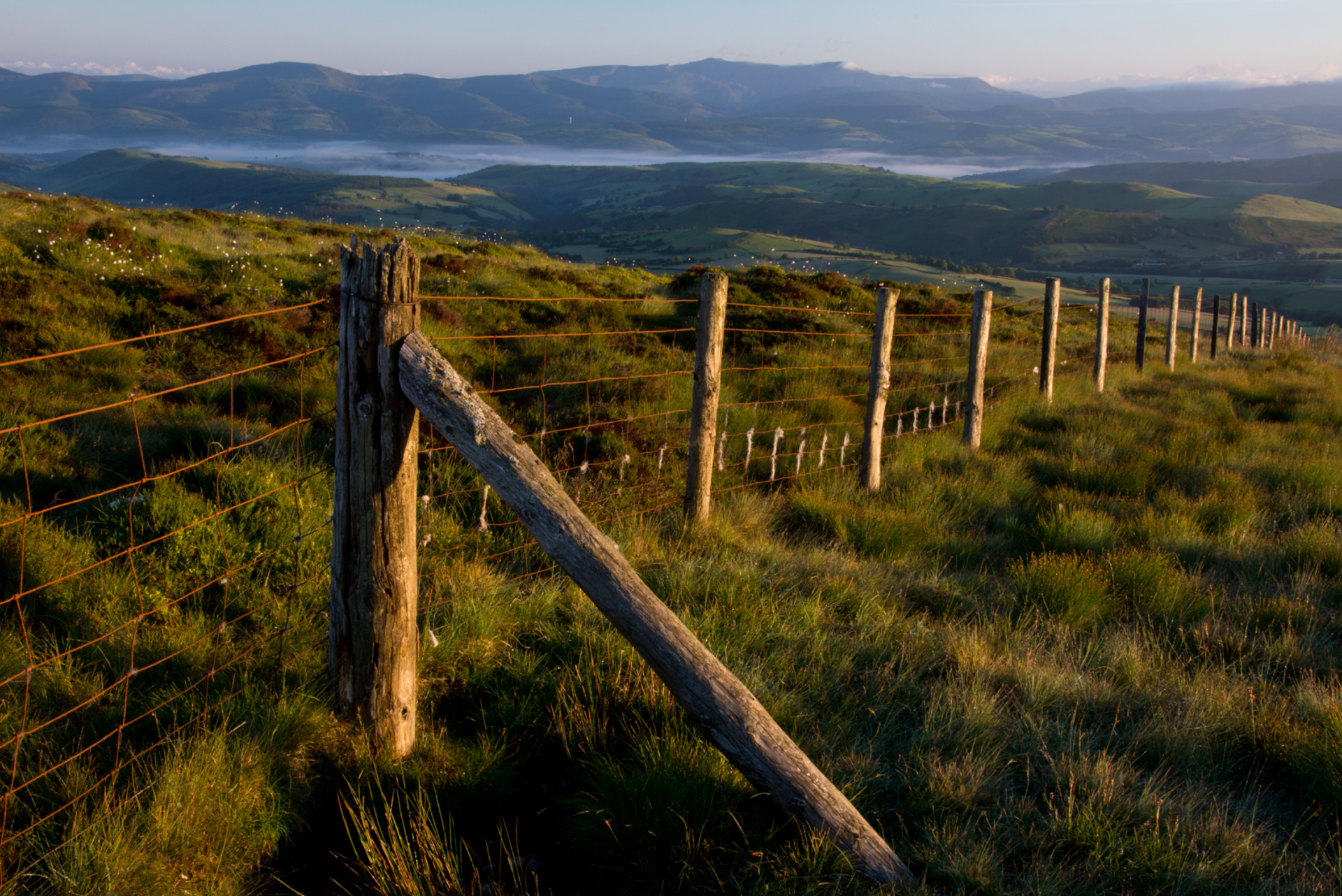 Fence line on Foel Fadian overlooking the hills and valleys of Mid Wales.