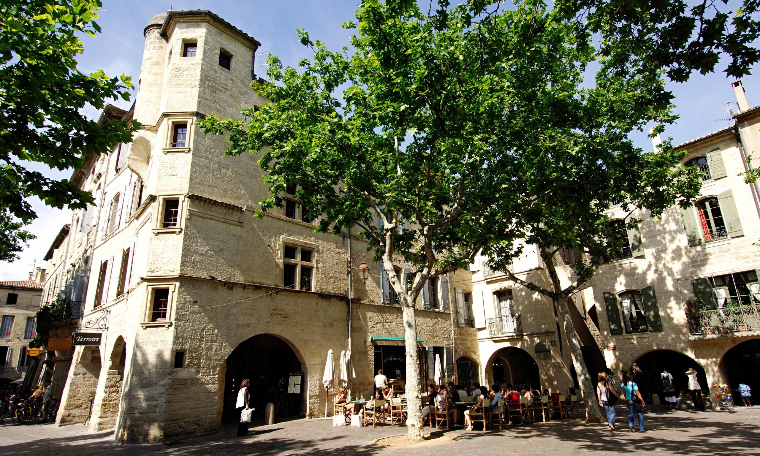 Cafés beneath plane trees in the Place aux Herbes in Uzès
