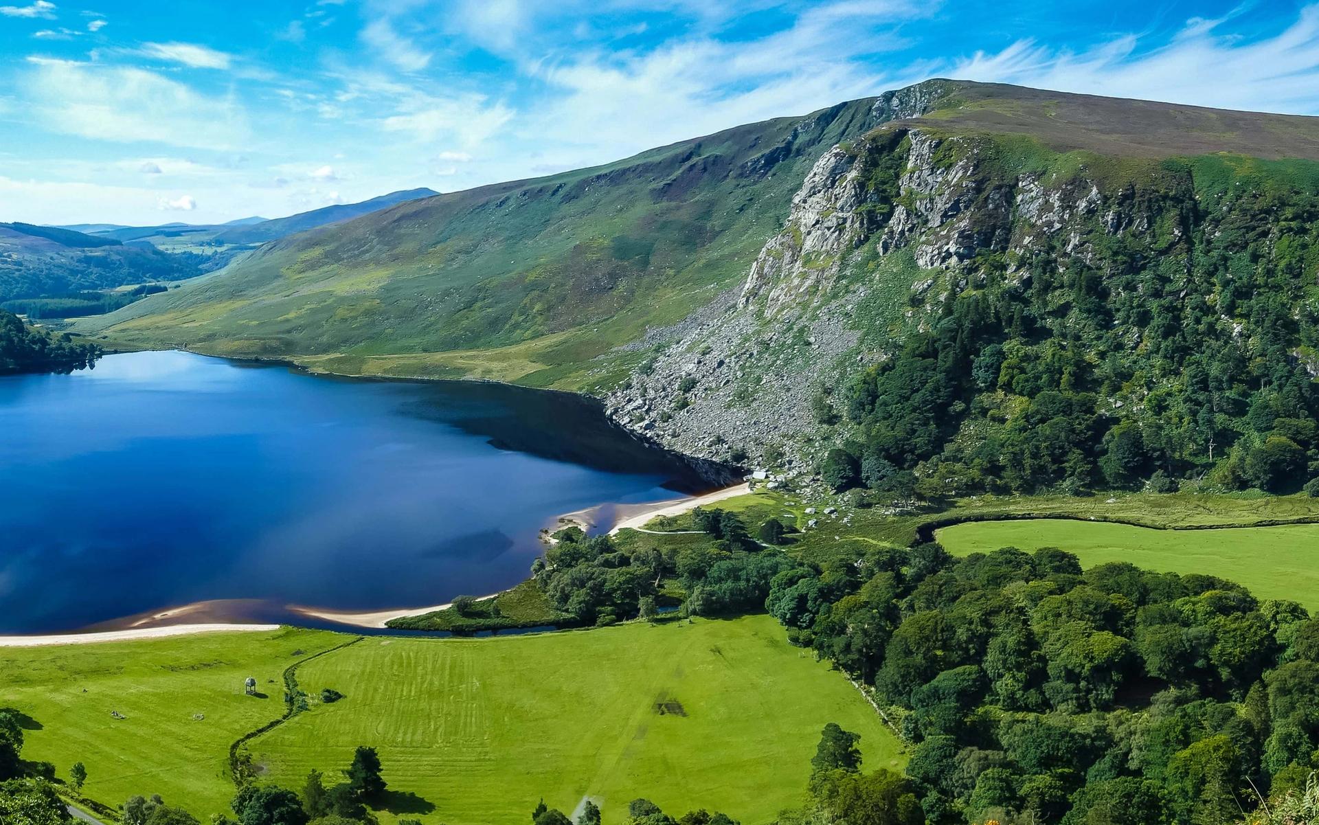 View across Upper Lake at Glendalough, surrounded by wooded hills