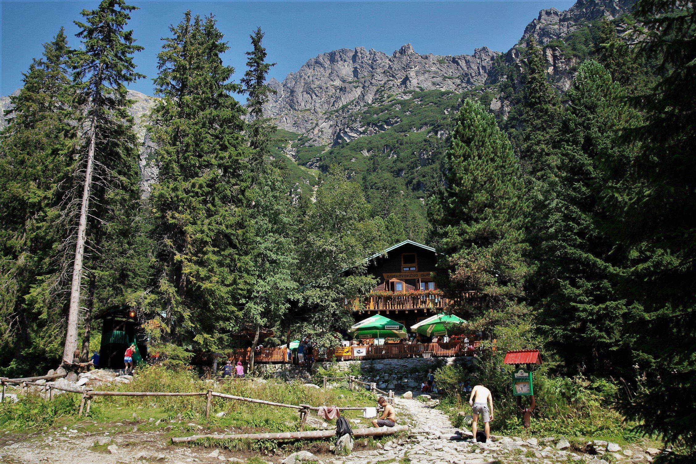 Mountain hut with walkers resting on a forest trail in the High Tatras