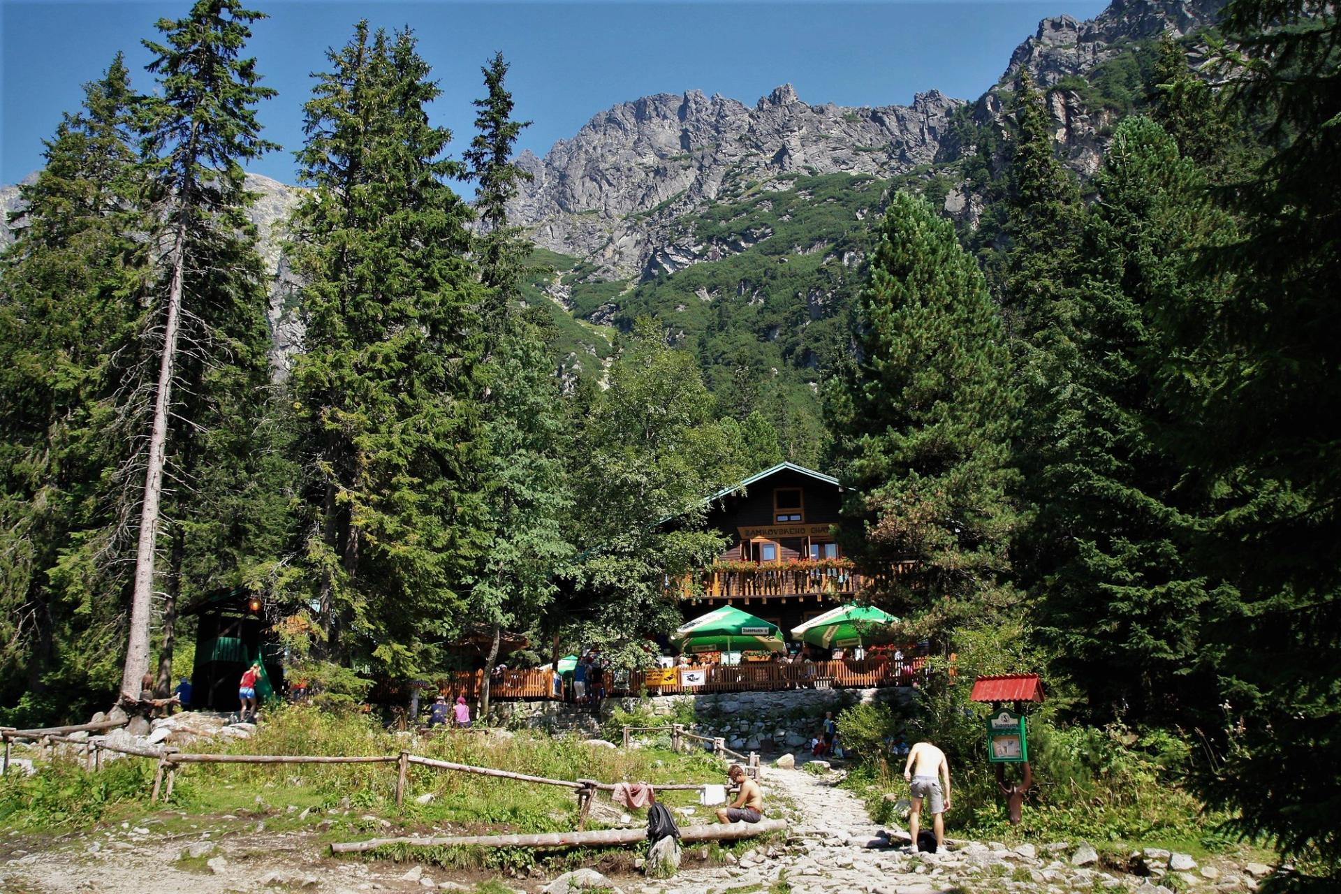 Mountain hut with walkers resting on a forest trail in the High Tatras