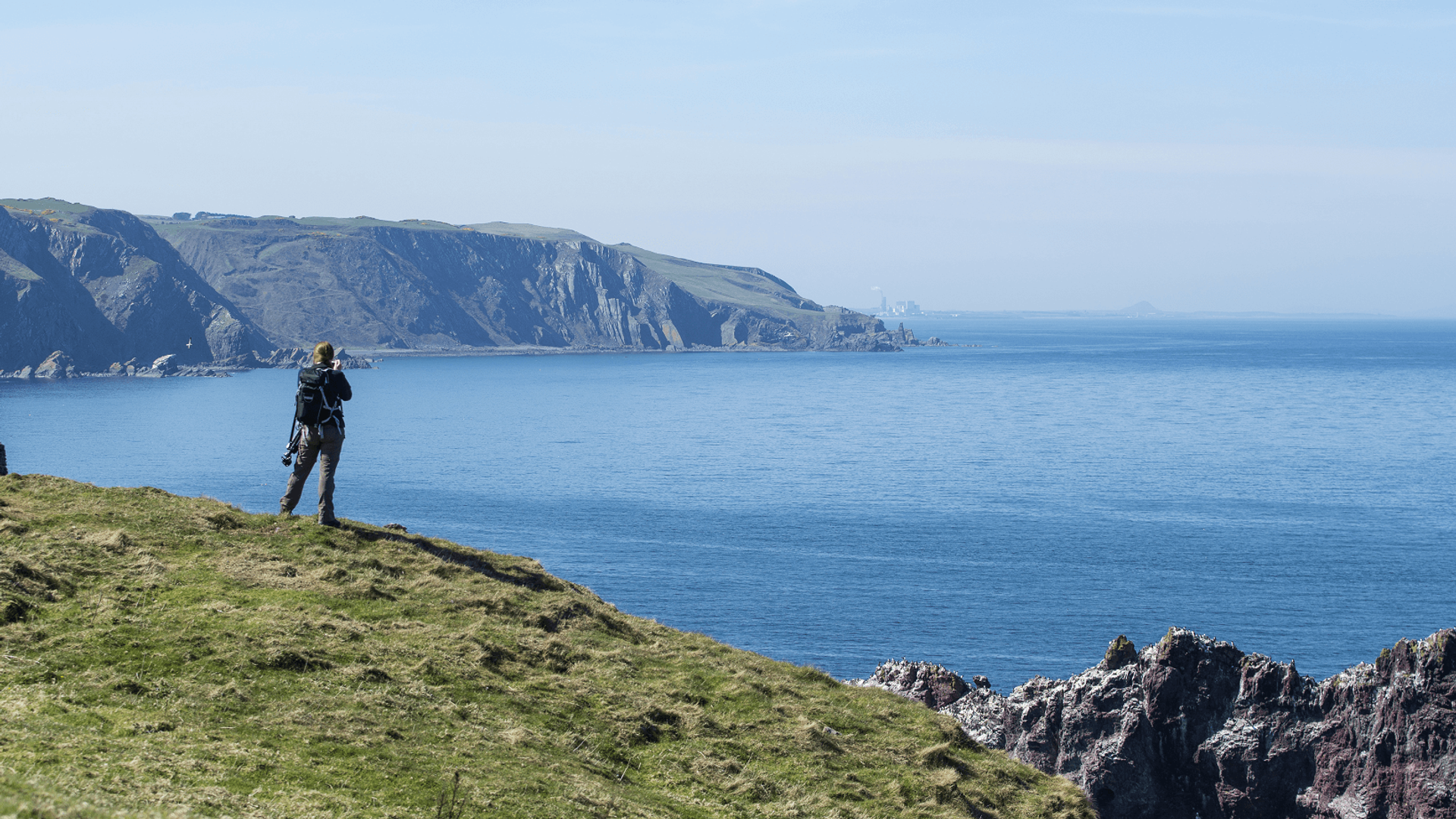 Man on cliff with binoculars