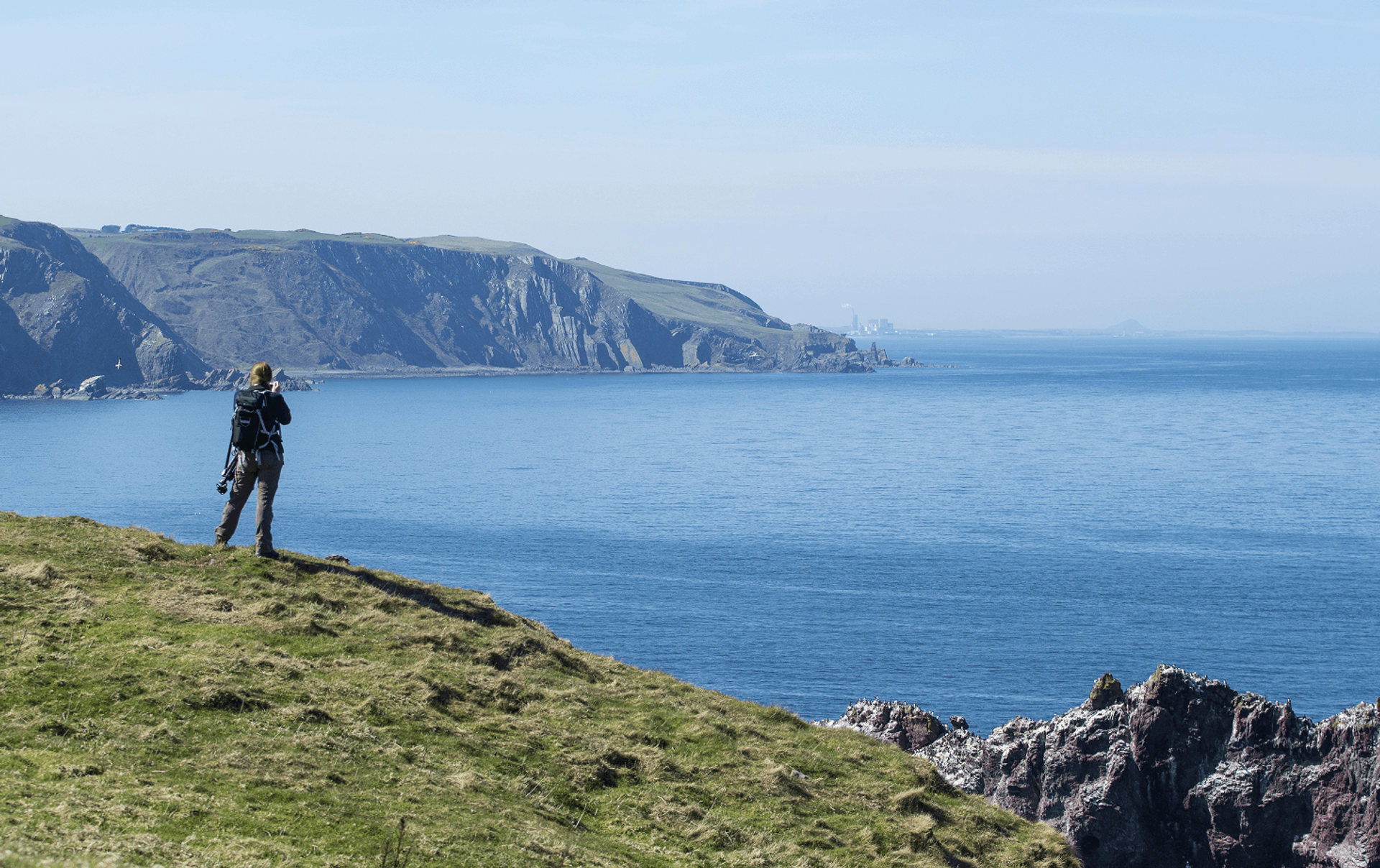 Man on cliff with binoculars
