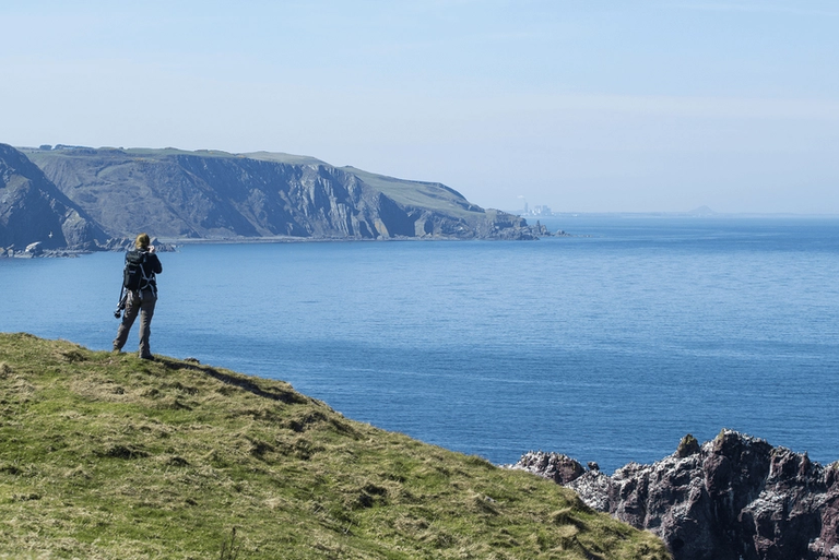Man on cliff with binoculars