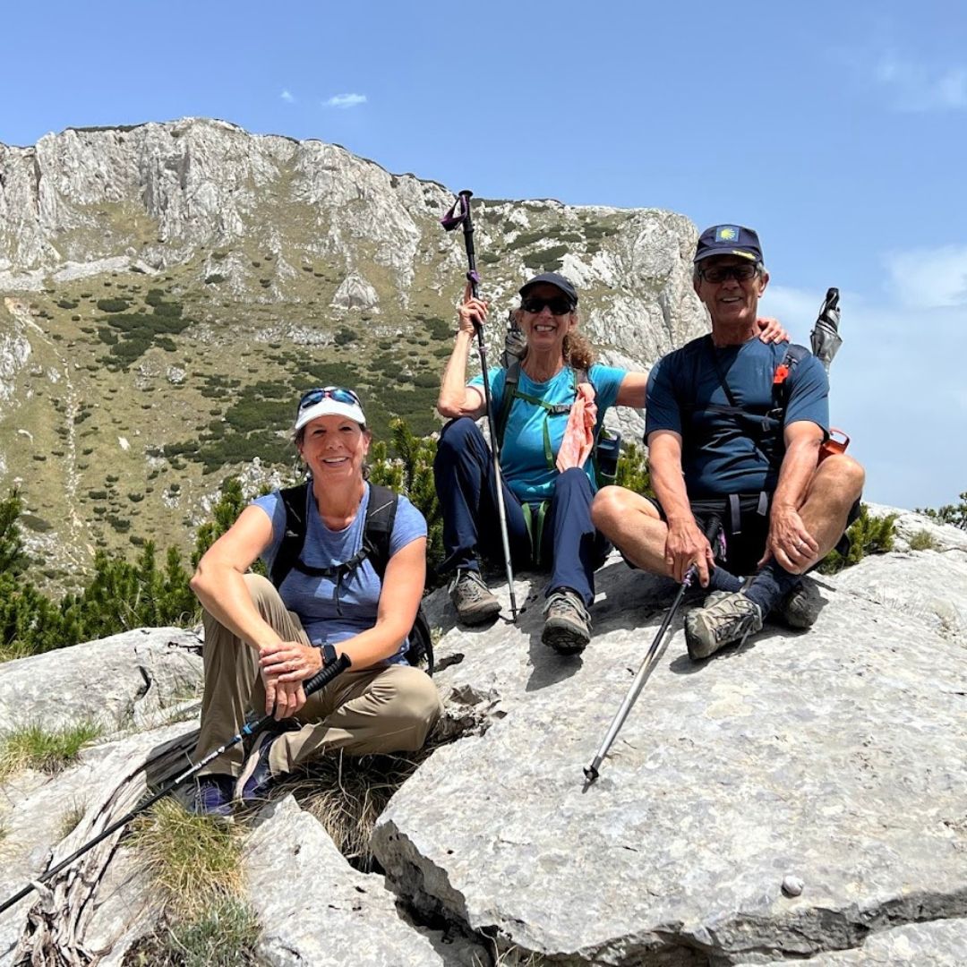 Walkers resting on a rock on a sunny day