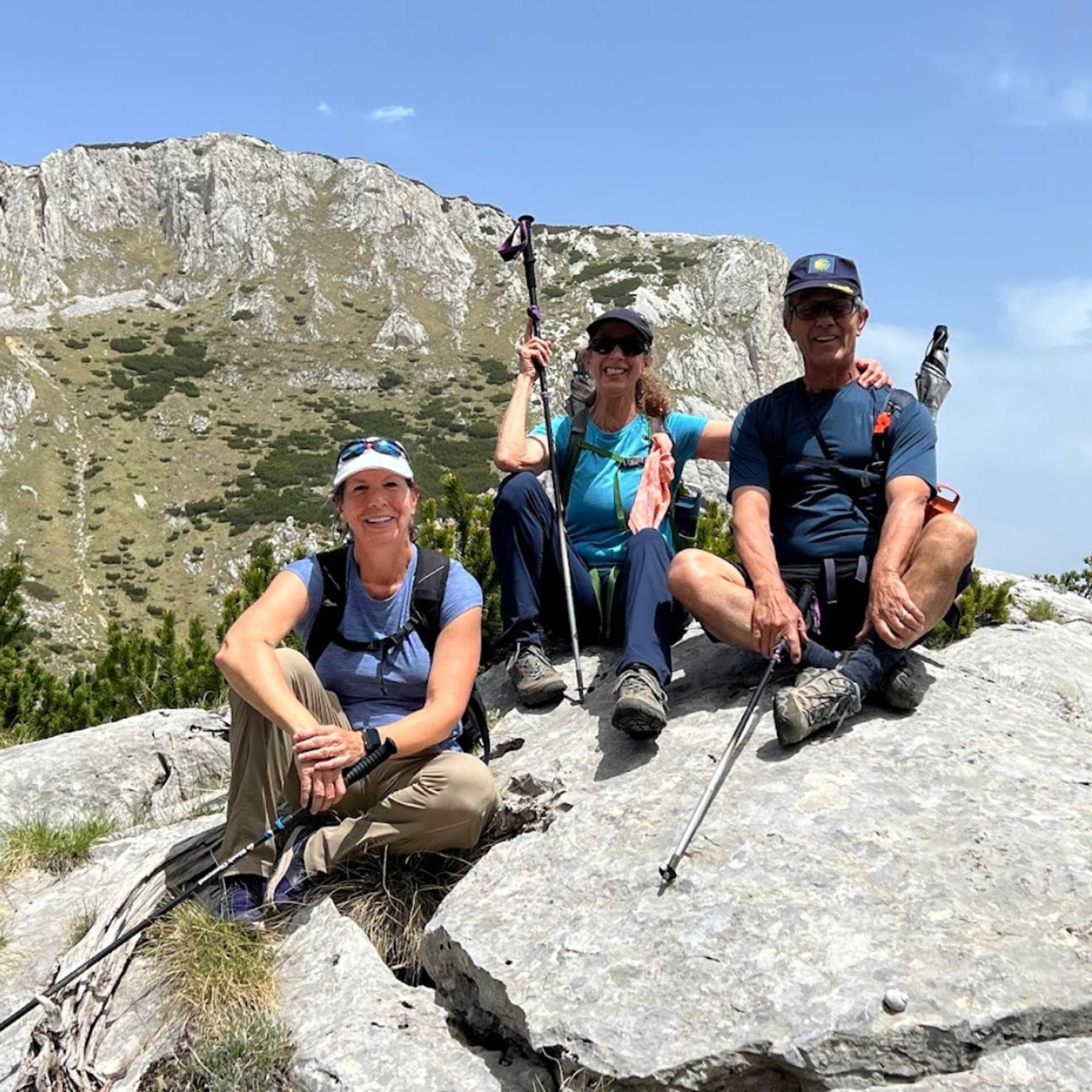 Walkers resting on a rock on a sunny day