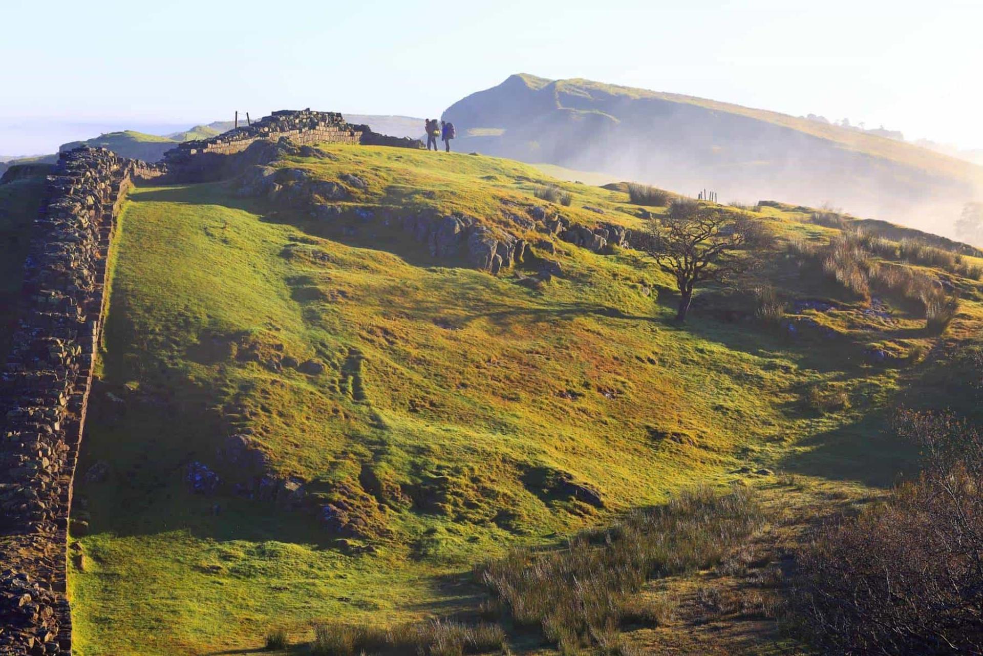 Walkers on Hadrian’s Wall Path along the Whin Sill ridge in Northumberland
