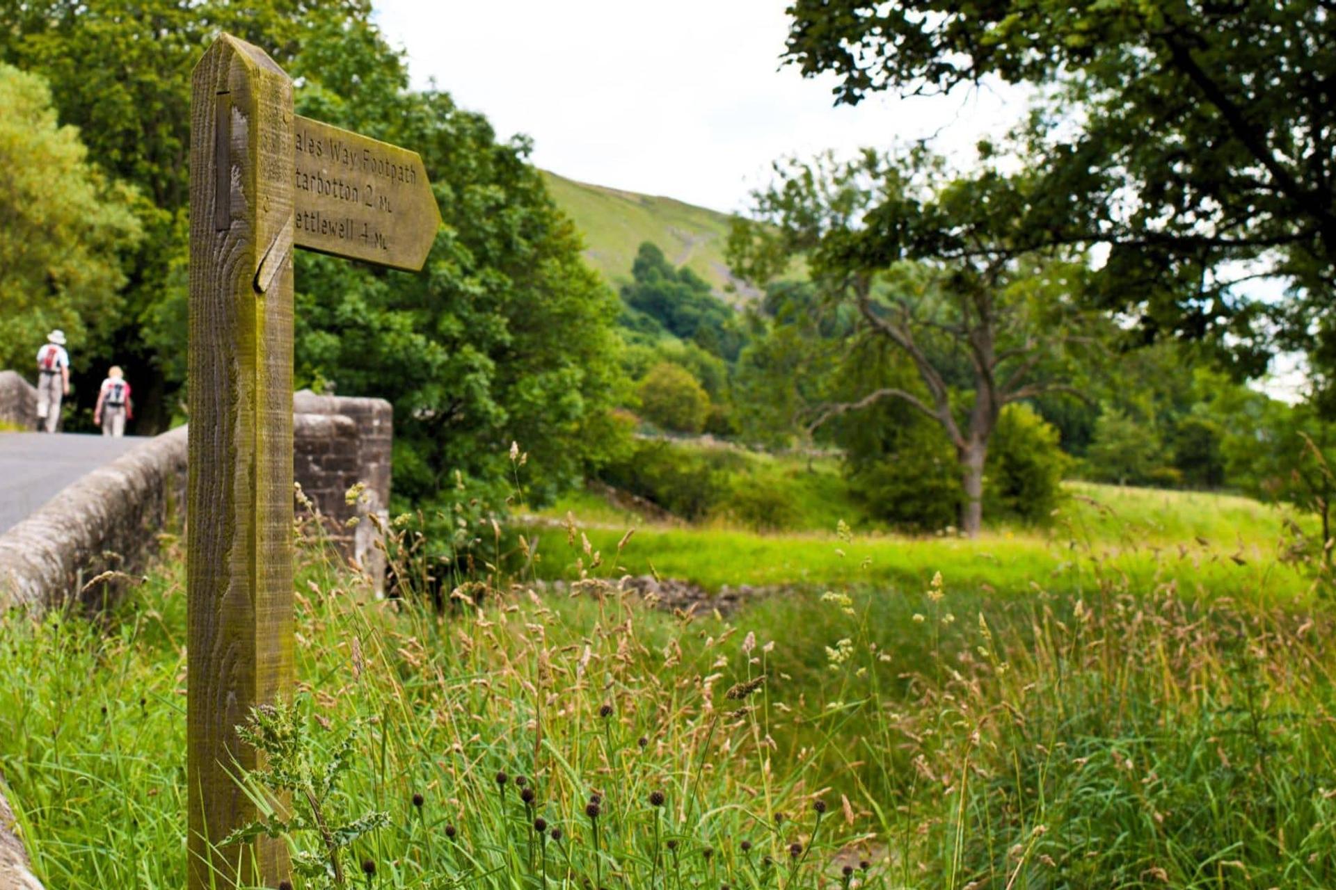 Sign and walkers on Dales Way Trail