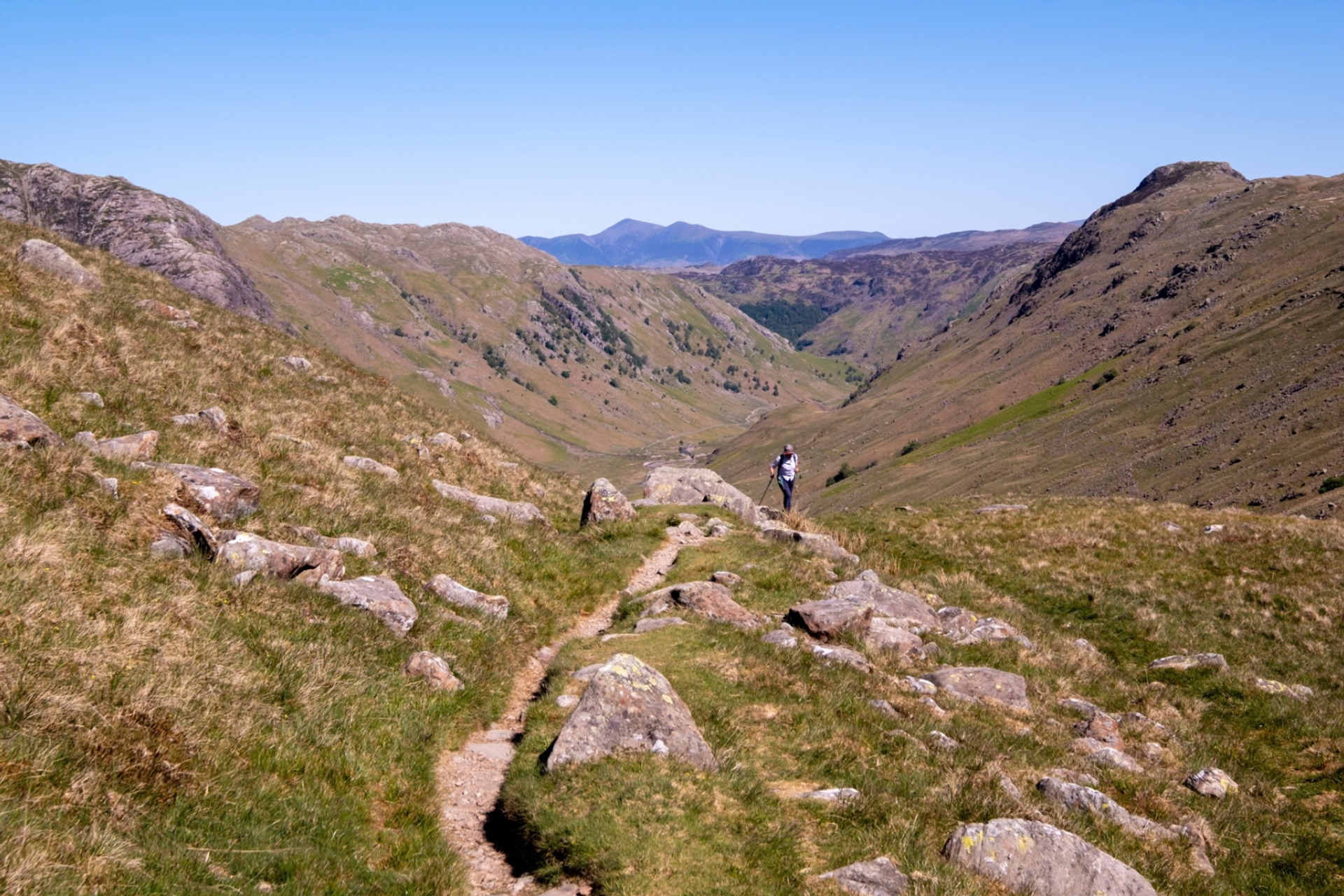 Walker following the rocky path over Stake Pass on the Cumbria Way.