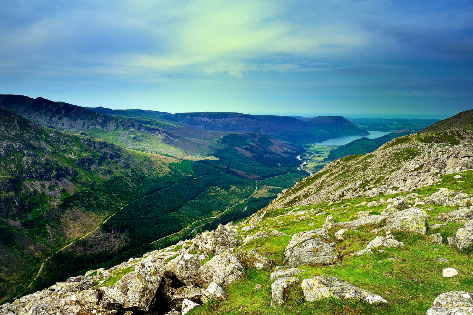 Rocky Lake District fells above a wooded valley on Wainwright’s Coast to Coast.
