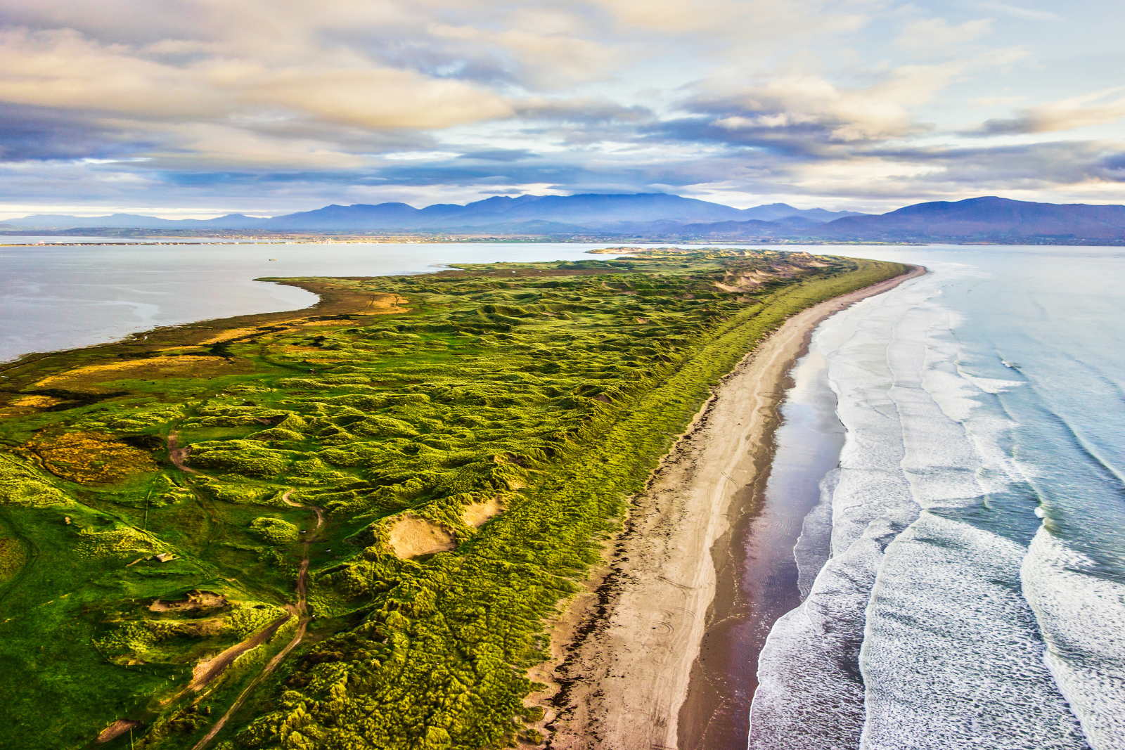 Aerial view of Inch Beach curving along the coast with mountains in the distance.
