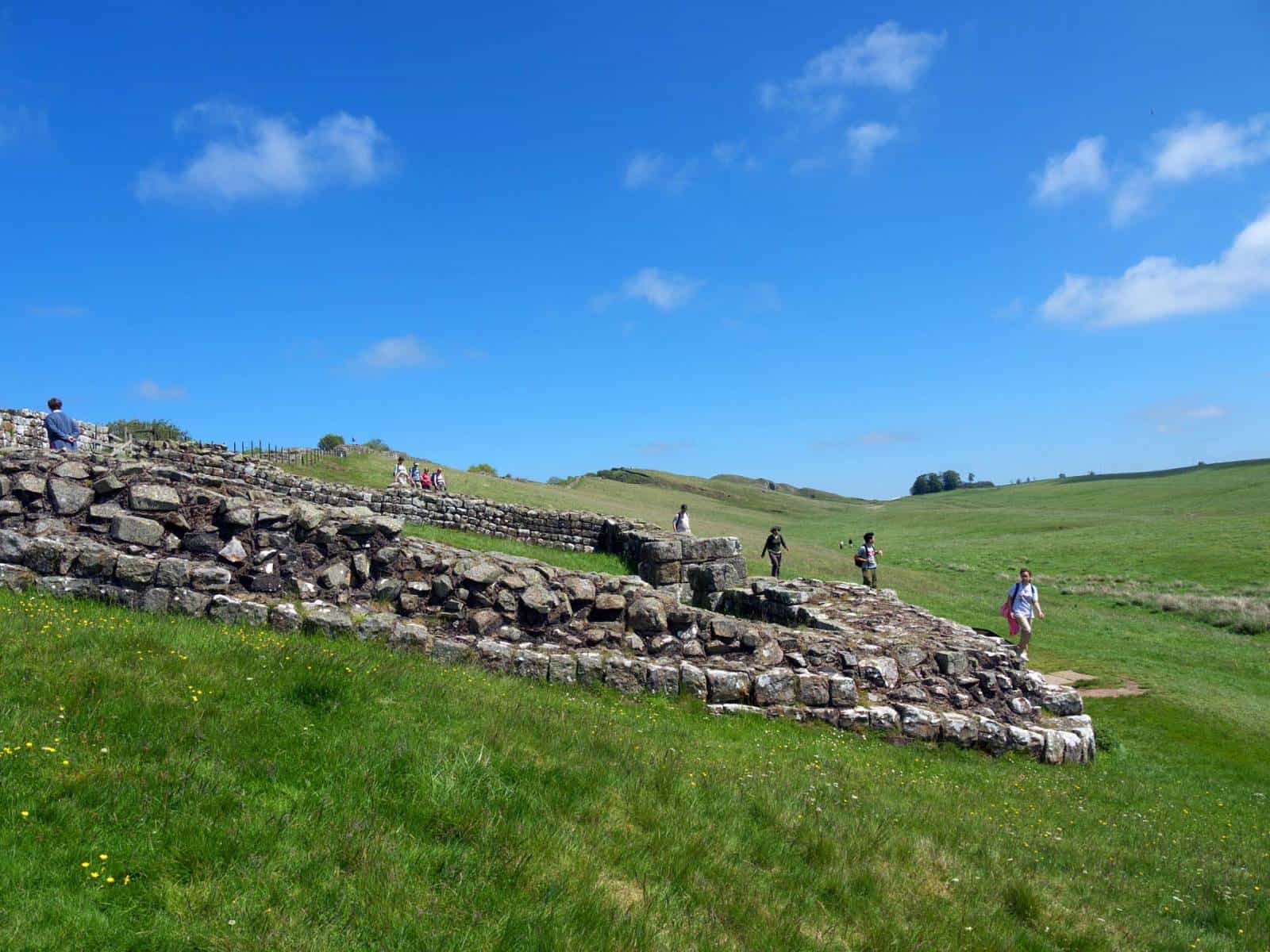 Visitors exploring Roman ruins along Hadrian’s Wall in Northumberland