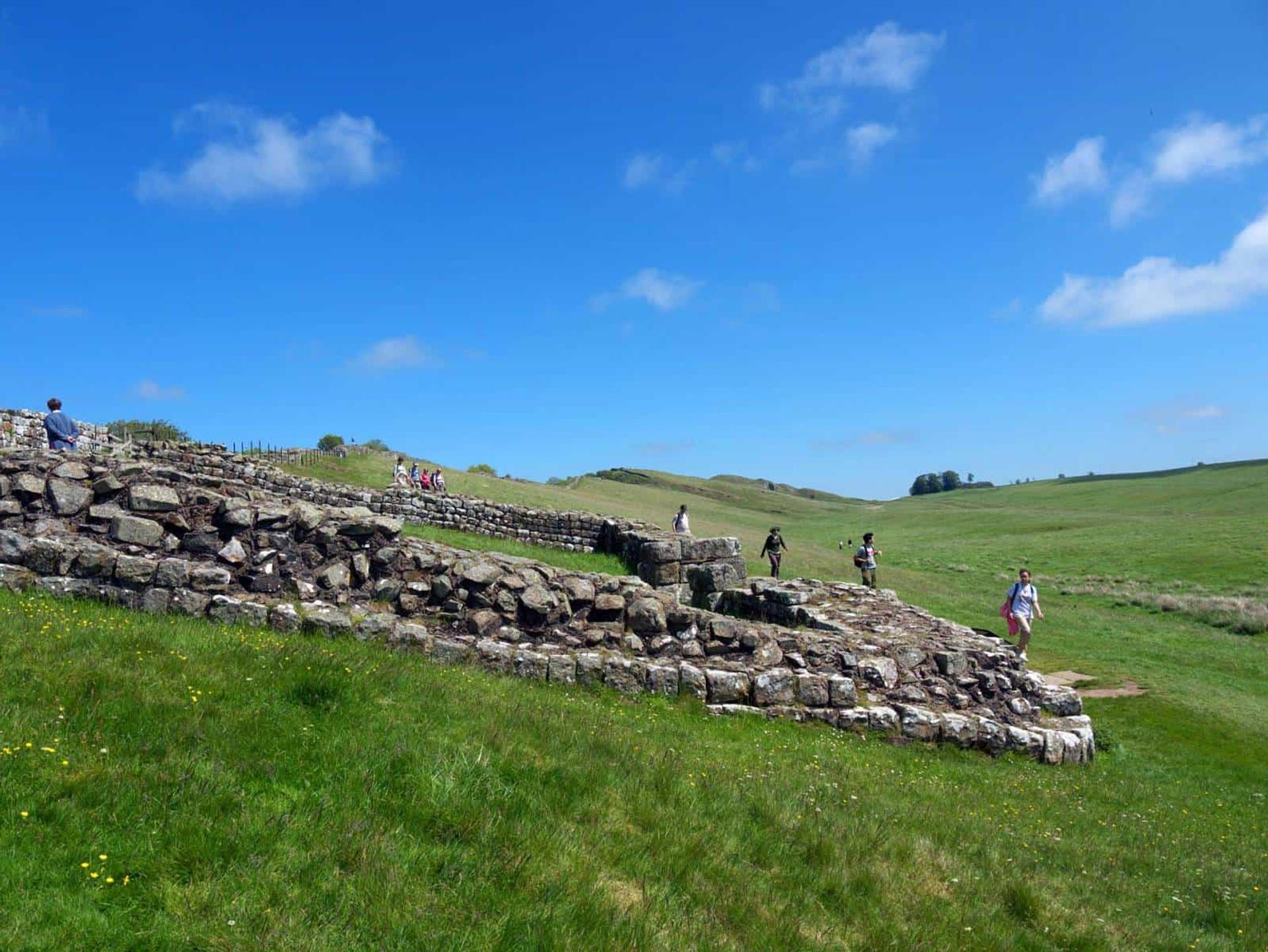 Visitors exploring Roman ruins along Hadrian’s Wall in Northumberland