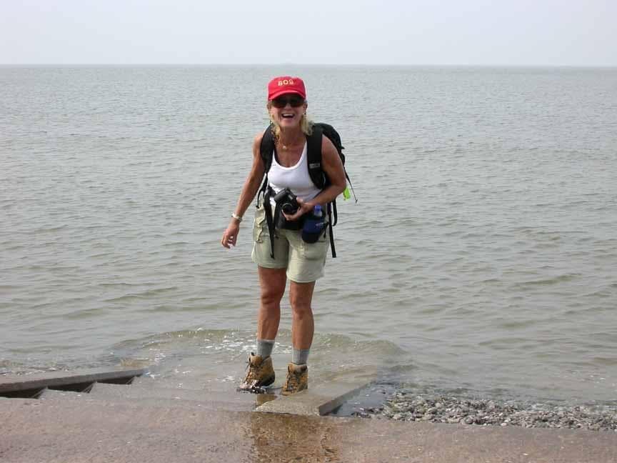 Walker dipping a boot in the sea at Prestatyn, marking the traditional end of Offa’s Dyke Path