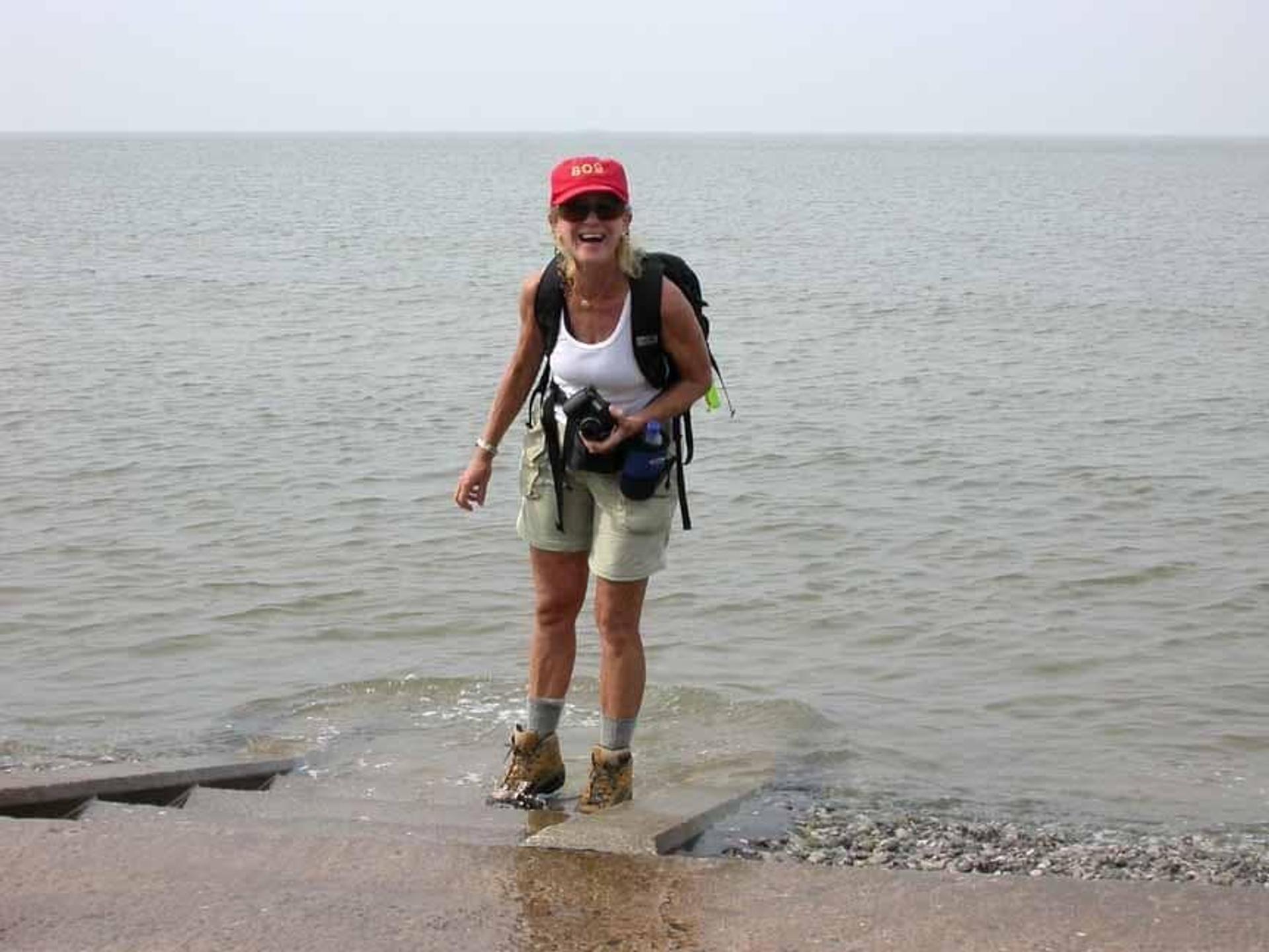 Walker dipping a boot in the sea at Prestatyn, marking the traditional end of Offa’s Dyke Path