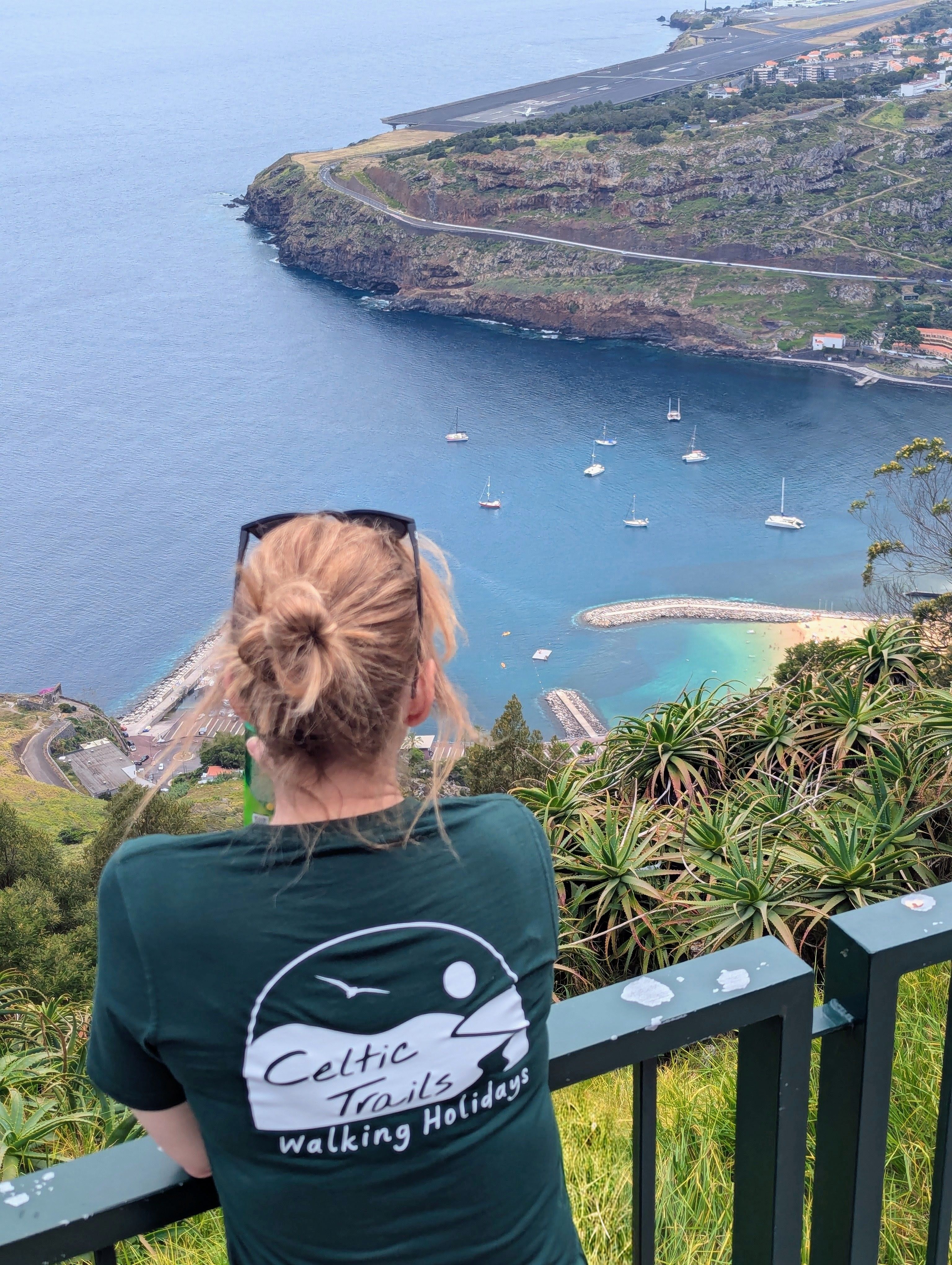 Walker overlooking Madeira's coastline, mountains and harbour from a panoramic viewpoint