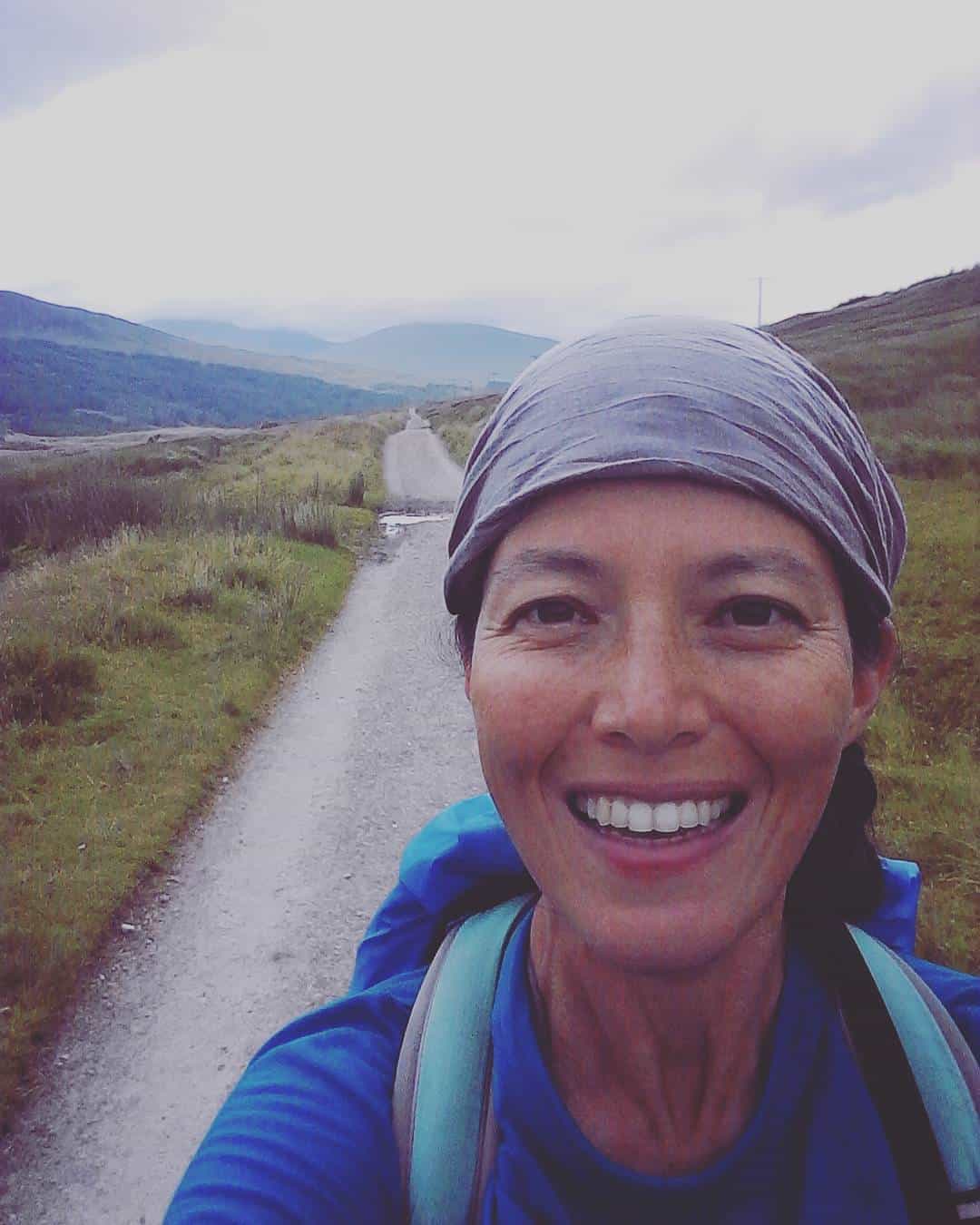 Smiling walker on the West Highland Way with hills in the background