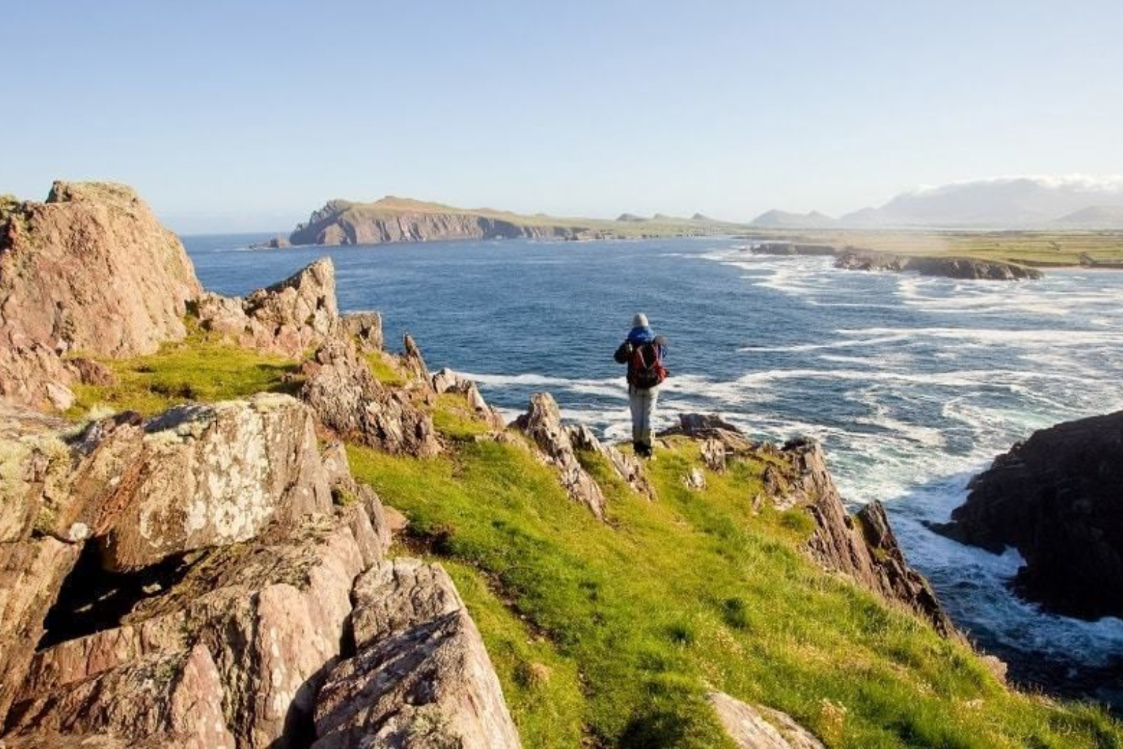 Walker on a rocky headland overlooking the Atlantic on the Dingle Way