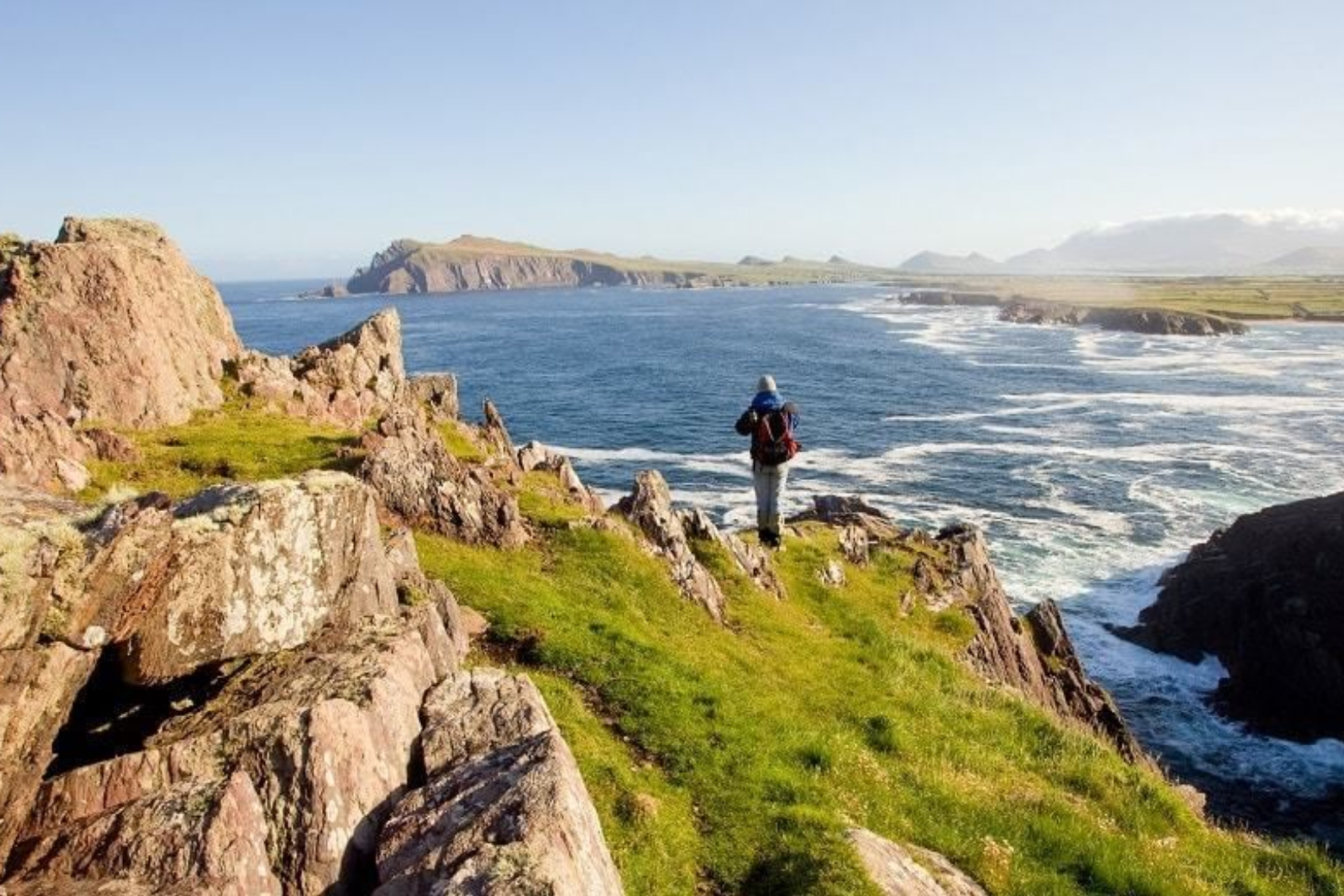 Walker on a rocky headland overlooking the Atlantic on the Dingle Way