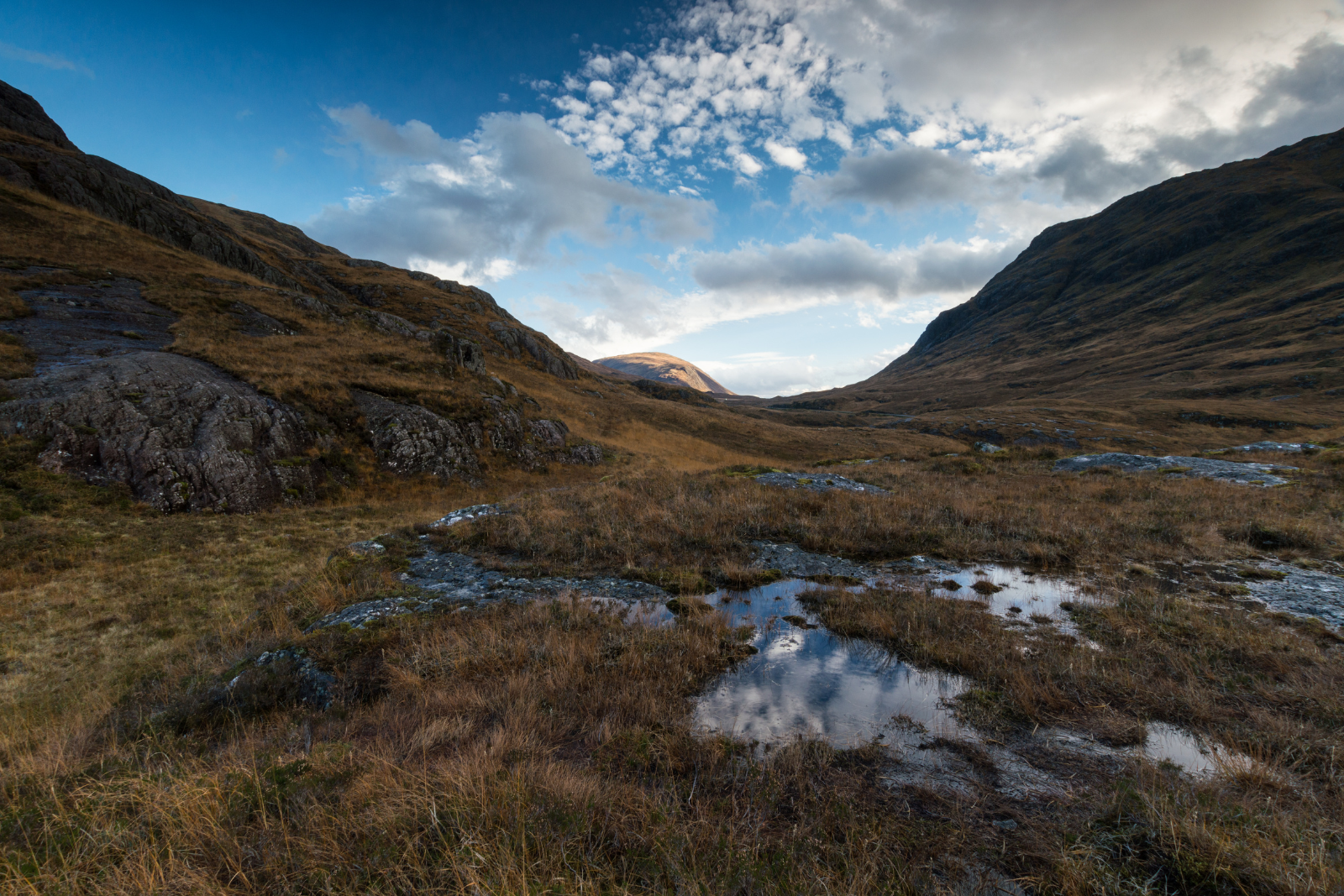 Open Highland moorland and rocky slopes along the West Highland Way beneath broken