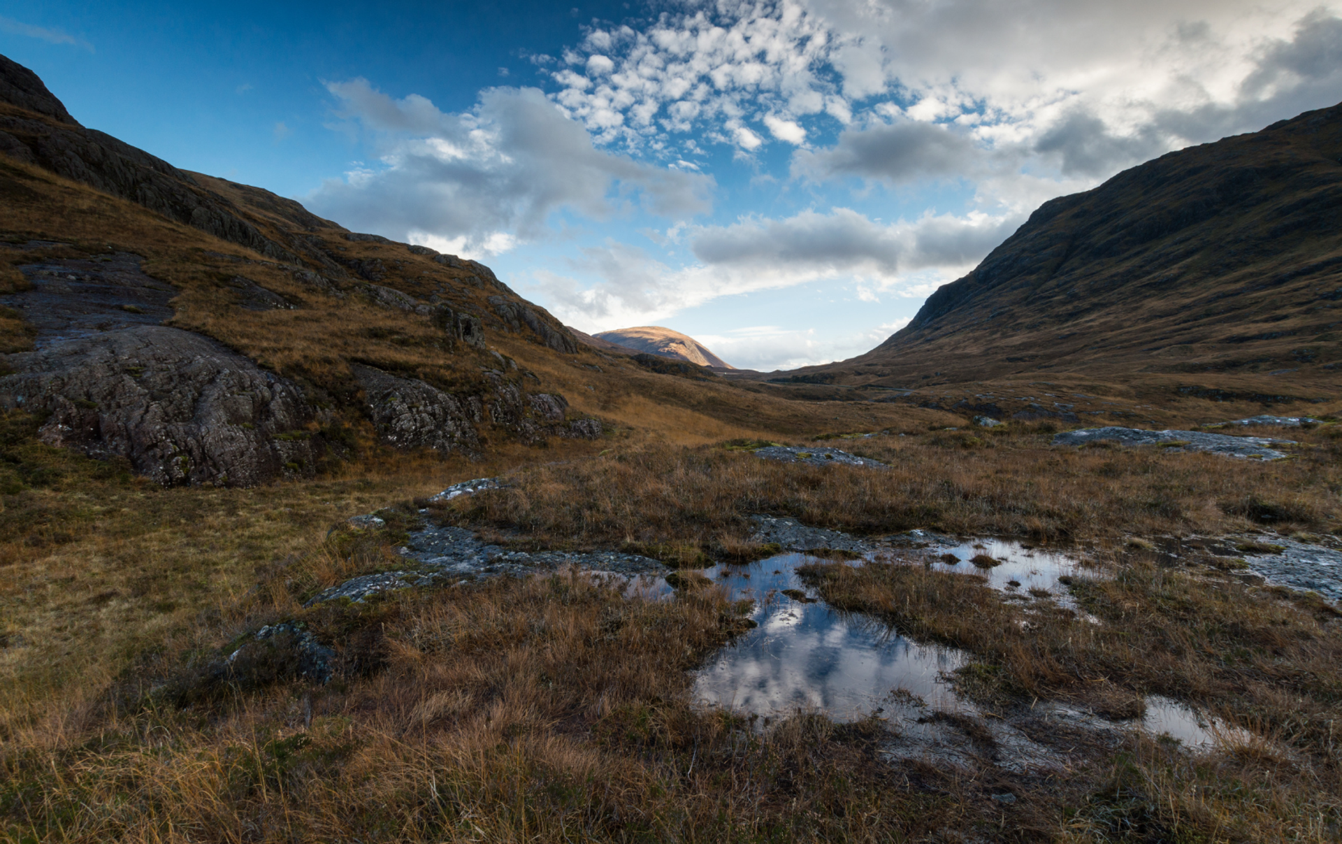 Open Highland moorland and rocky slopes along the West Highland Way beneath broken