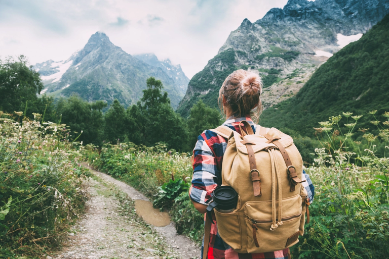 Hiker Walking to Mountains with backpack