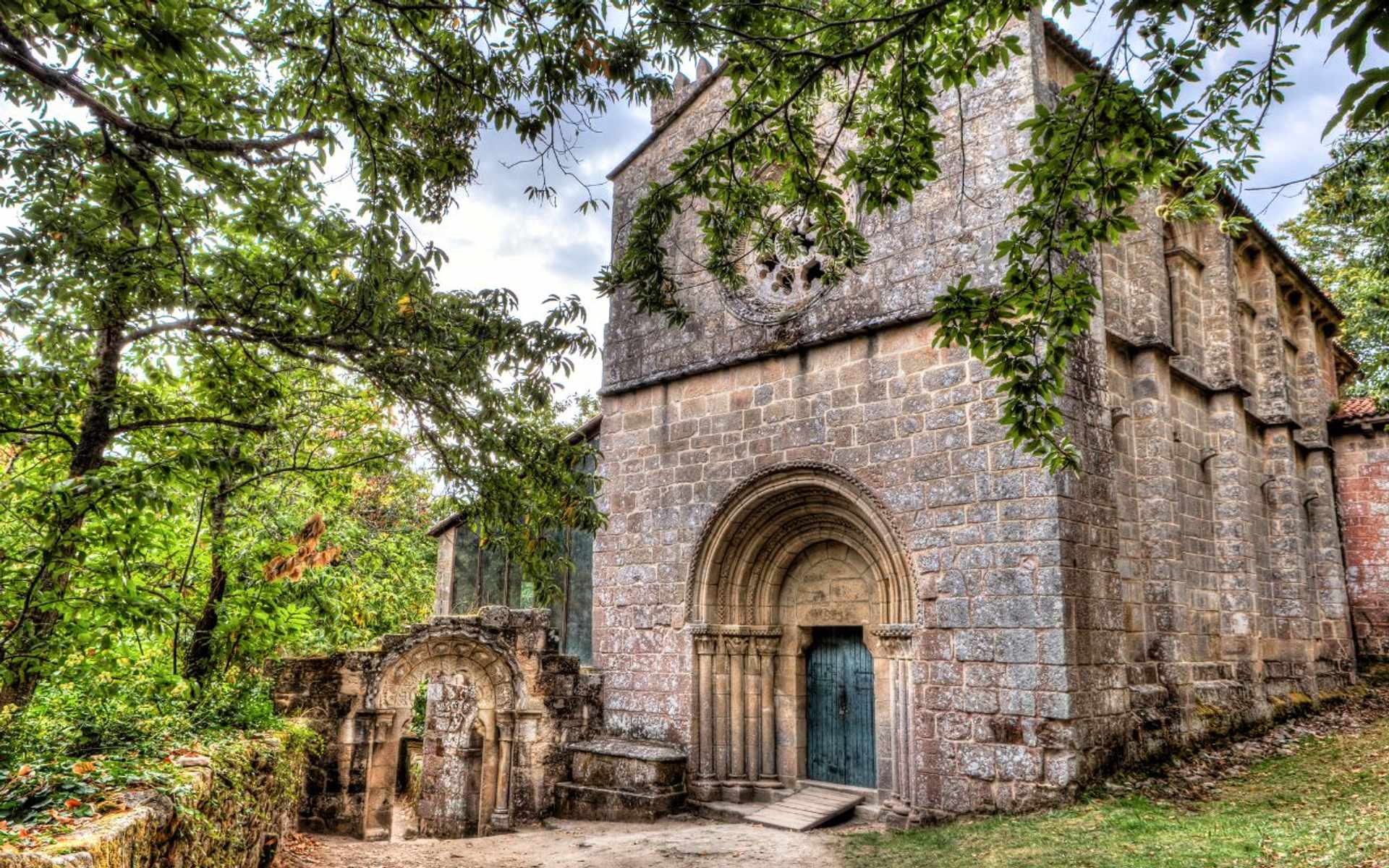 Historic Romanesque monastery with stone arch doorway in Ribeira Sacra, Galicia