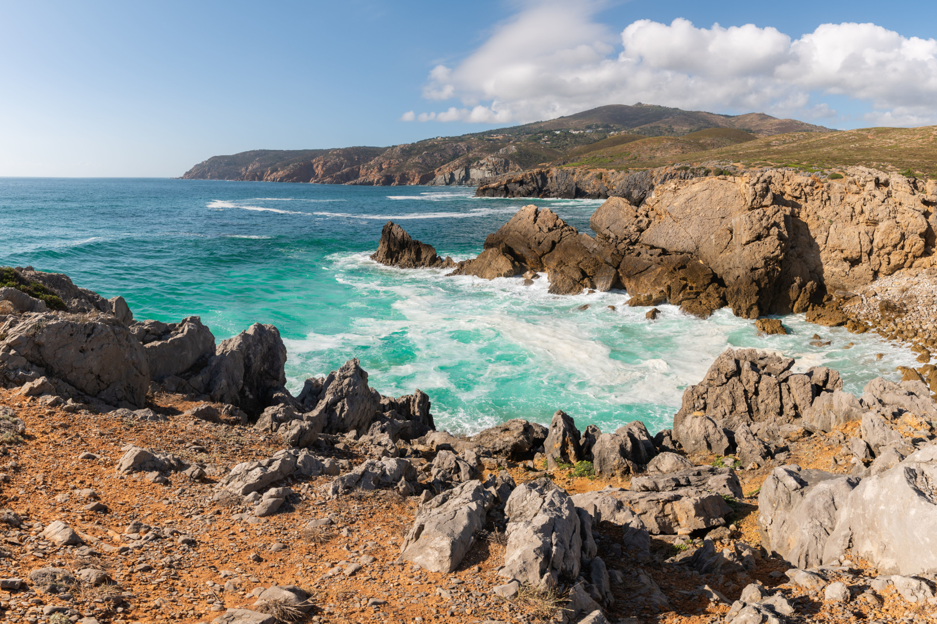 Atlantic waves breaking against rocky cliffs along the Sintra-Cascais coast in Portugal.
