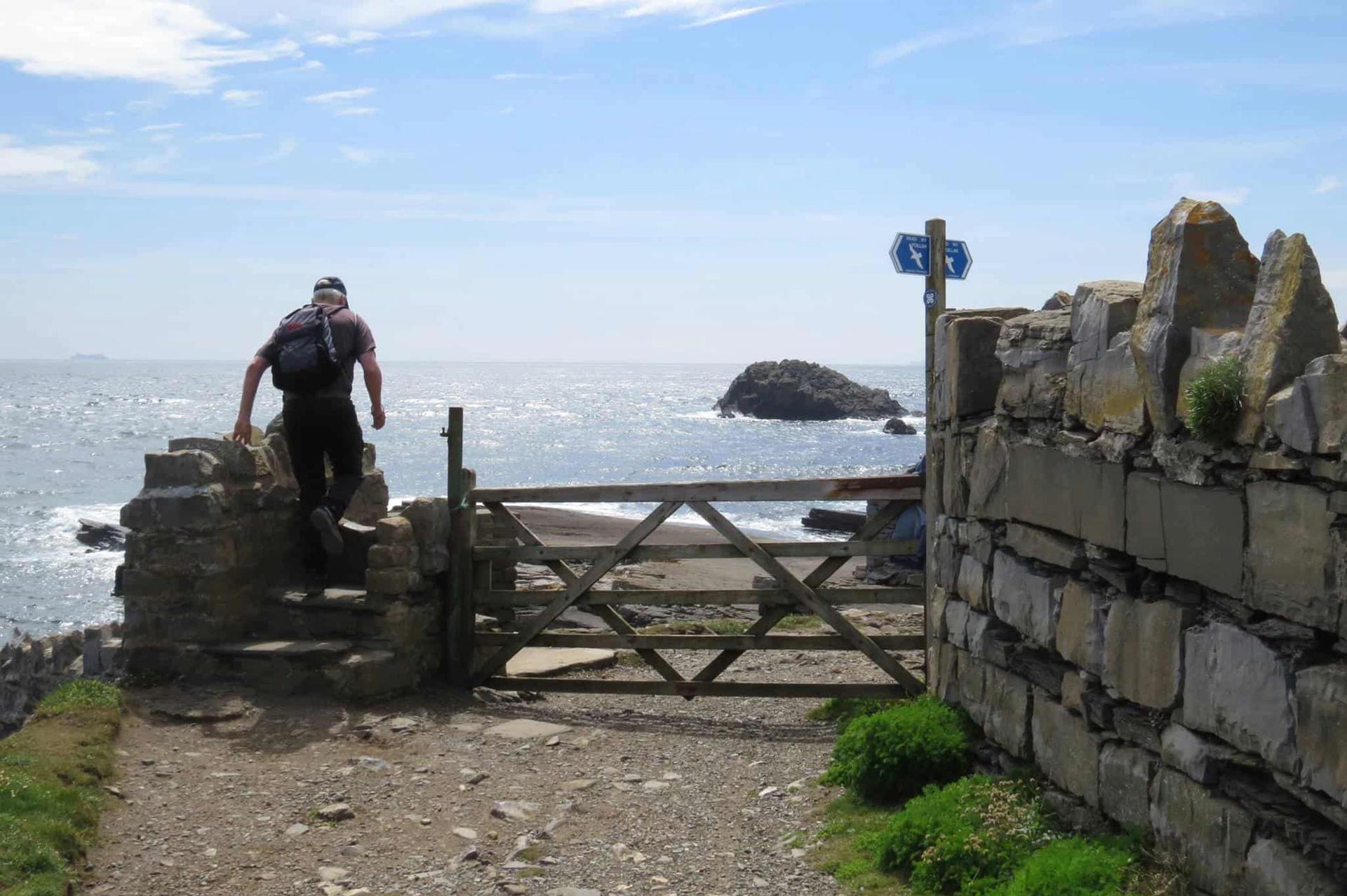 Climbing over a stile on the Isle of Man Coastal Path