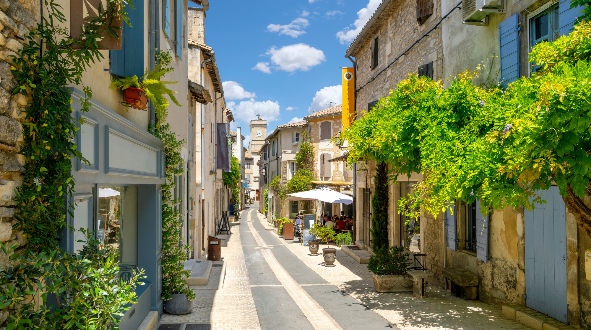 Stone street with blue shutters and greenery in Saint-Rémy-de-Provence