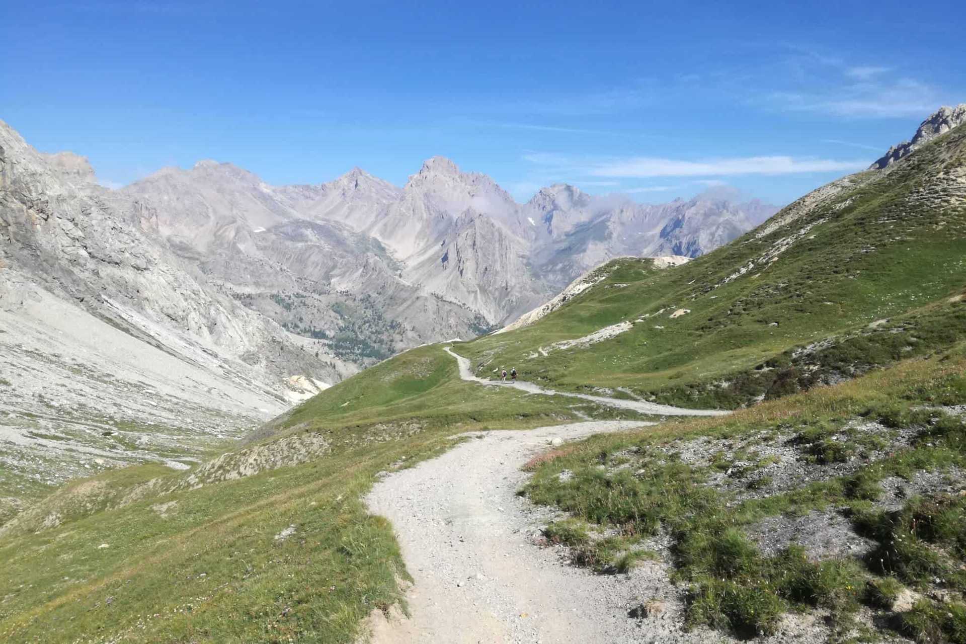 Hiking trail through grassy alpine meadows of the Gardetta Pass in the Val Maira region