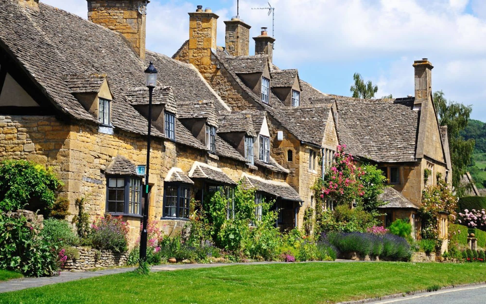 Honey-coloured stone cottages and gardens along the Cotswold Way in England.