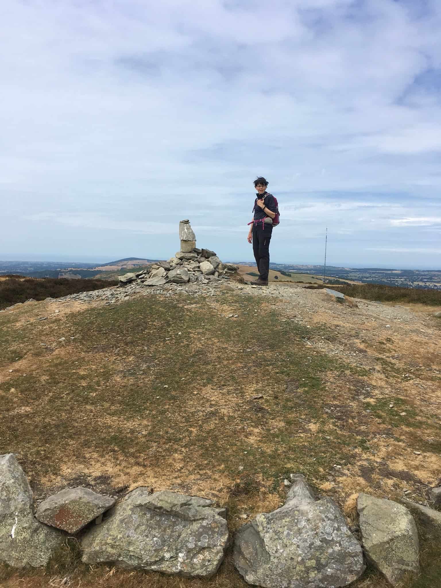 Walker at the summit of Moel Famau on the Offa’s Dyke Path in the Clwydian Range