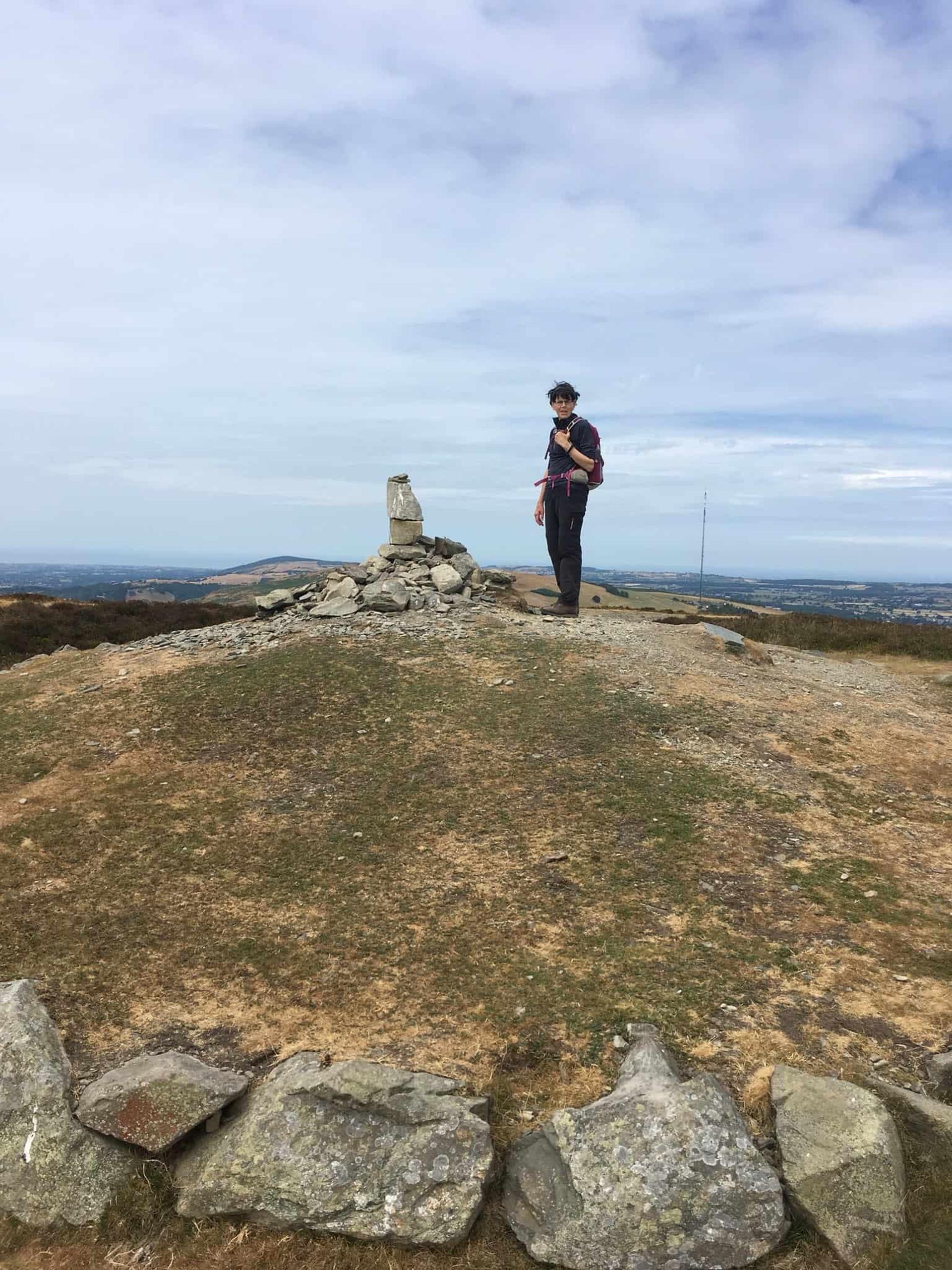 Walker at the summit of Moel Famau on the Offa’s Dyke Path in the Clwydian Range