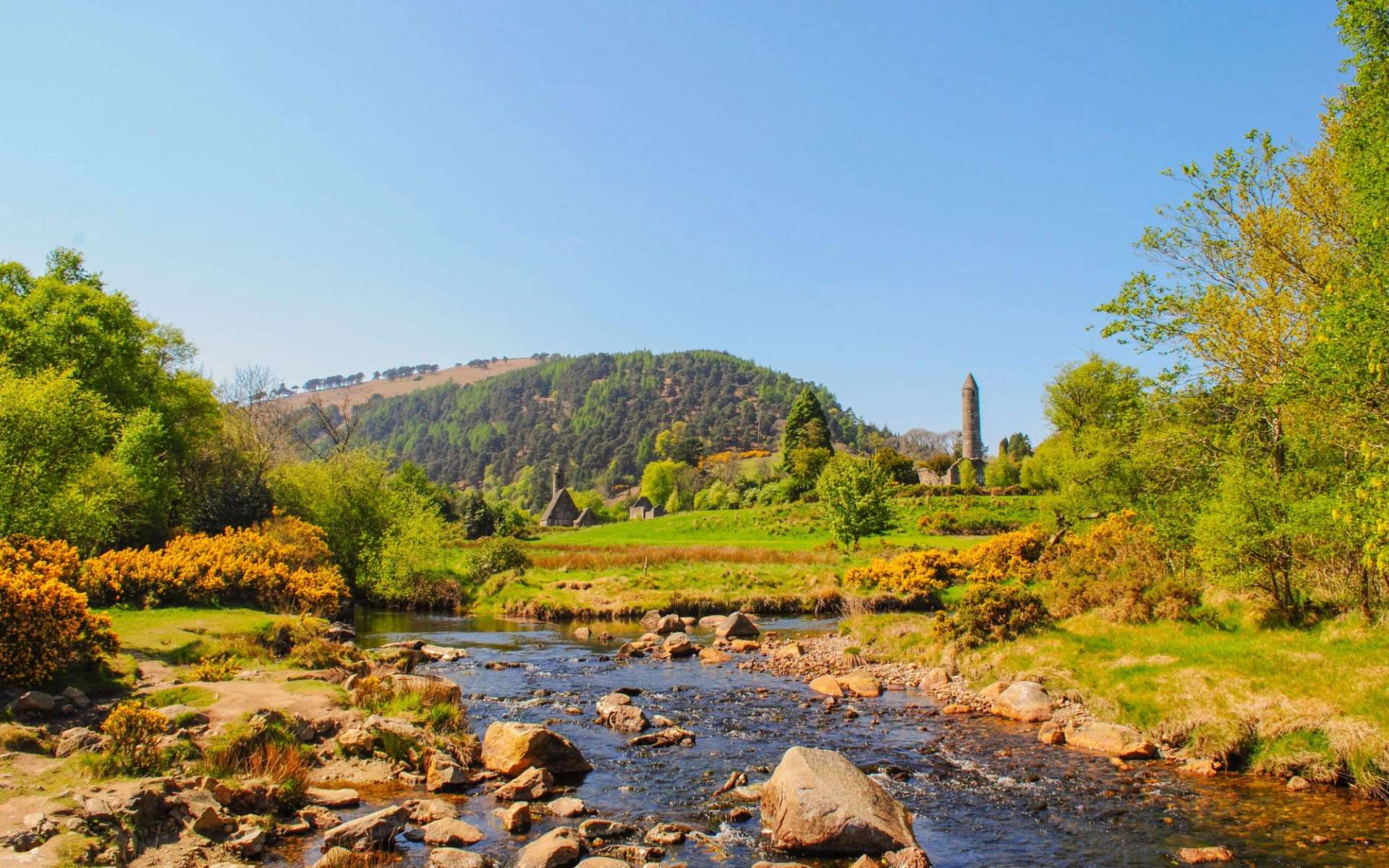 Round tower at Glendalough viewed from across the river in spring