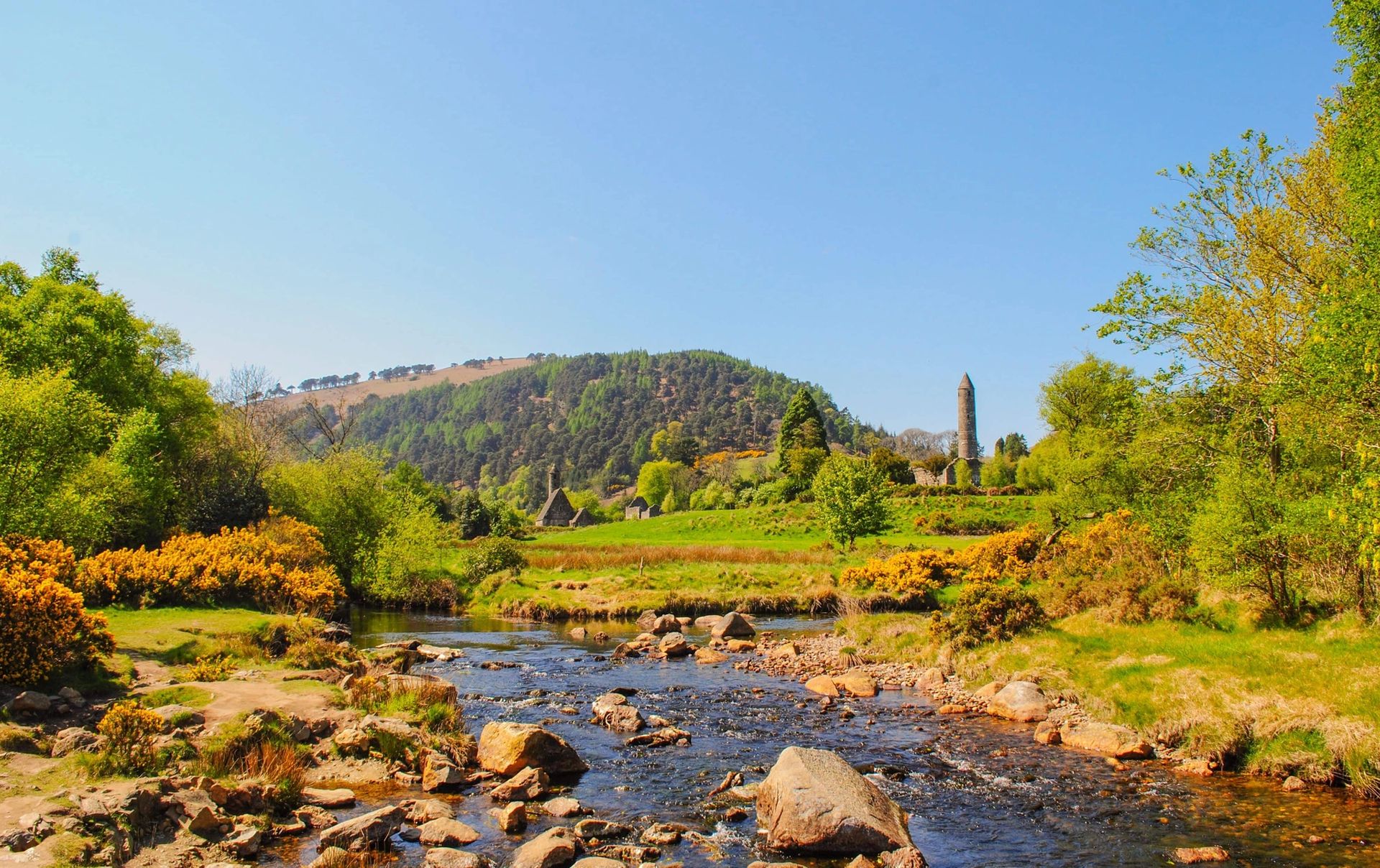 Round tower at Glendalough viewed from across the river in spring