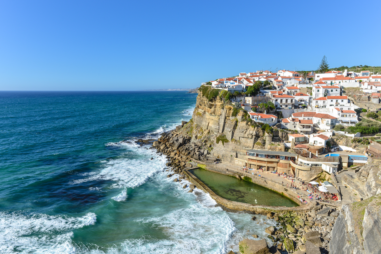 Whitewashed houses with terracotta roofs perched above the Atlantic cliffs at Azenhas do Mar.