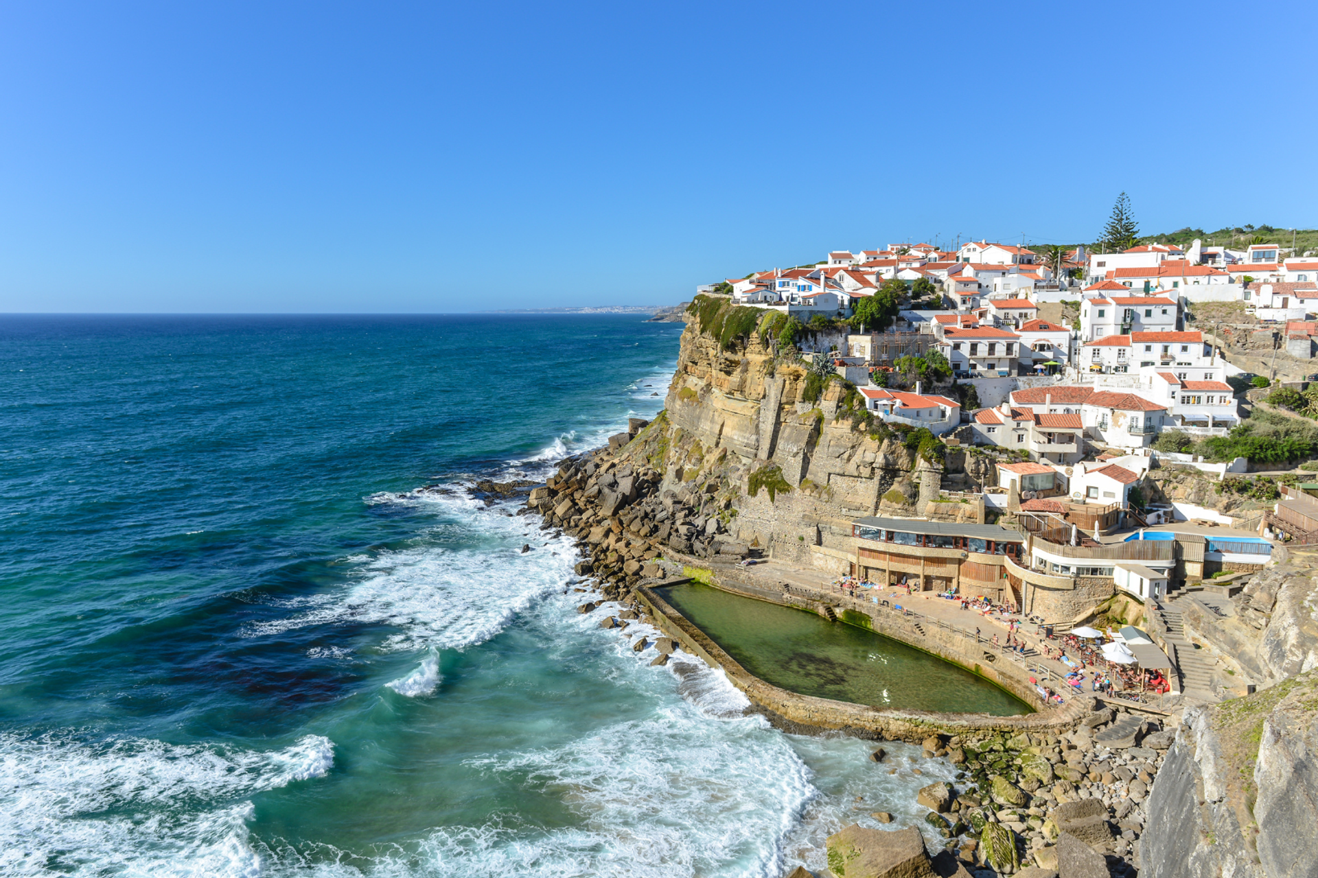 Whitewashed houses with terracotta roofs perched above the Atlantic cliffs at Azenhas do Mar.