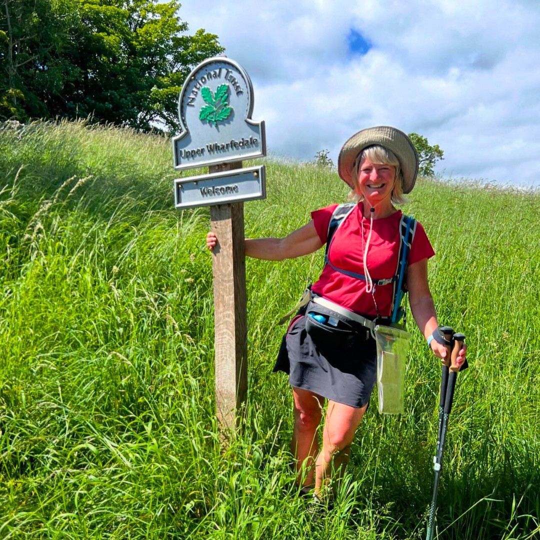 Walker beside the Upper Wharfedale National Trail sign on the Dales Way
