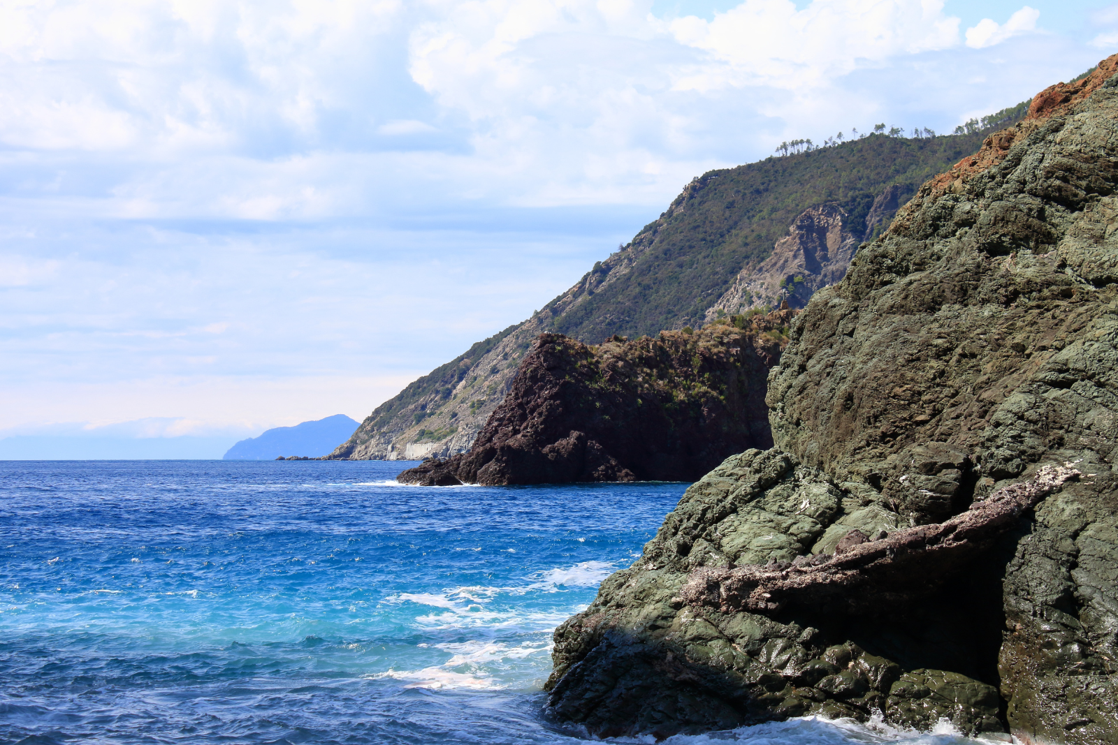 Rocky cliffs and blue Mediterranean waters along the coast near Framura.