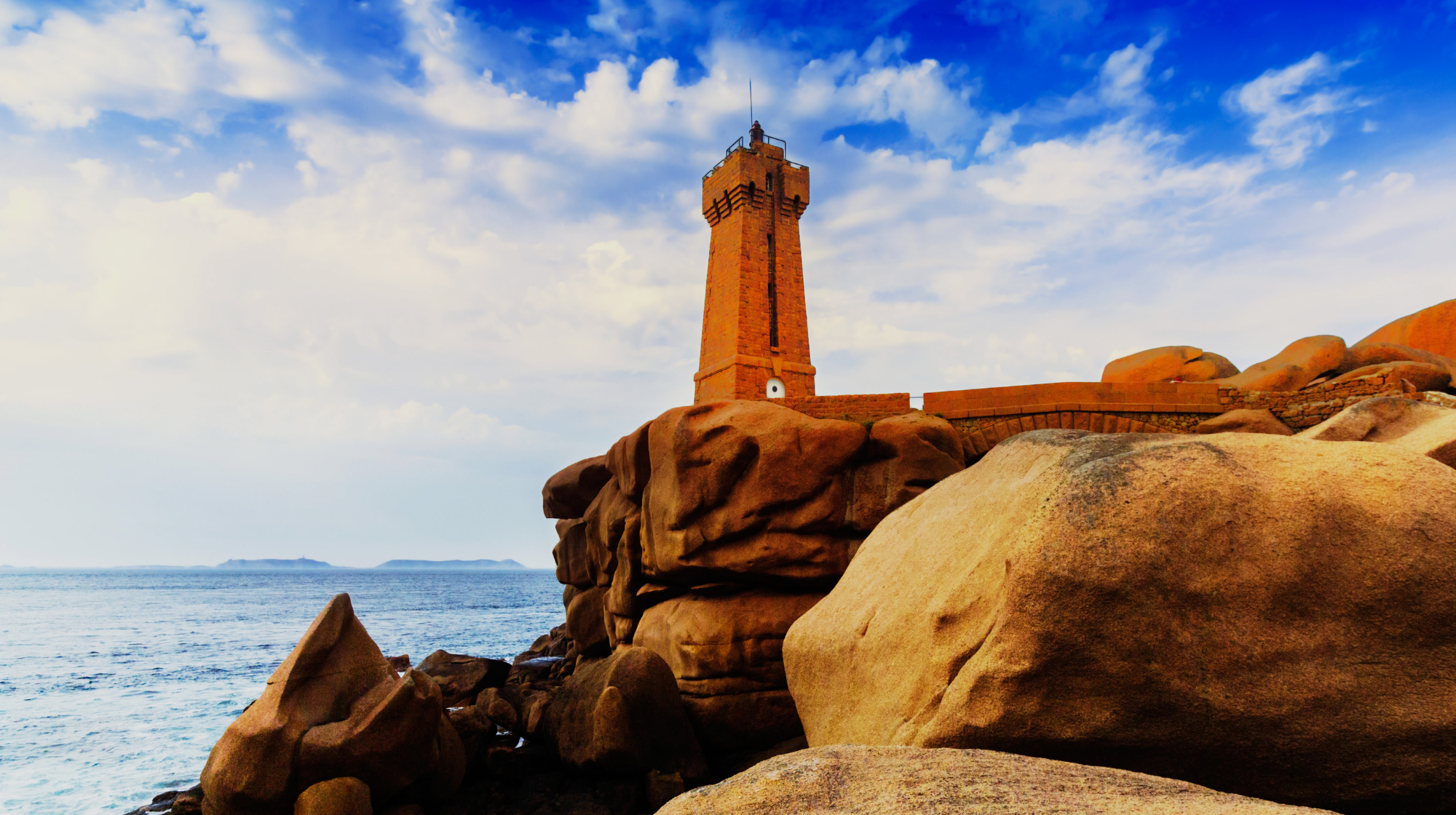 Lighthouse standing among pink granite rocks near Ploumanac’h