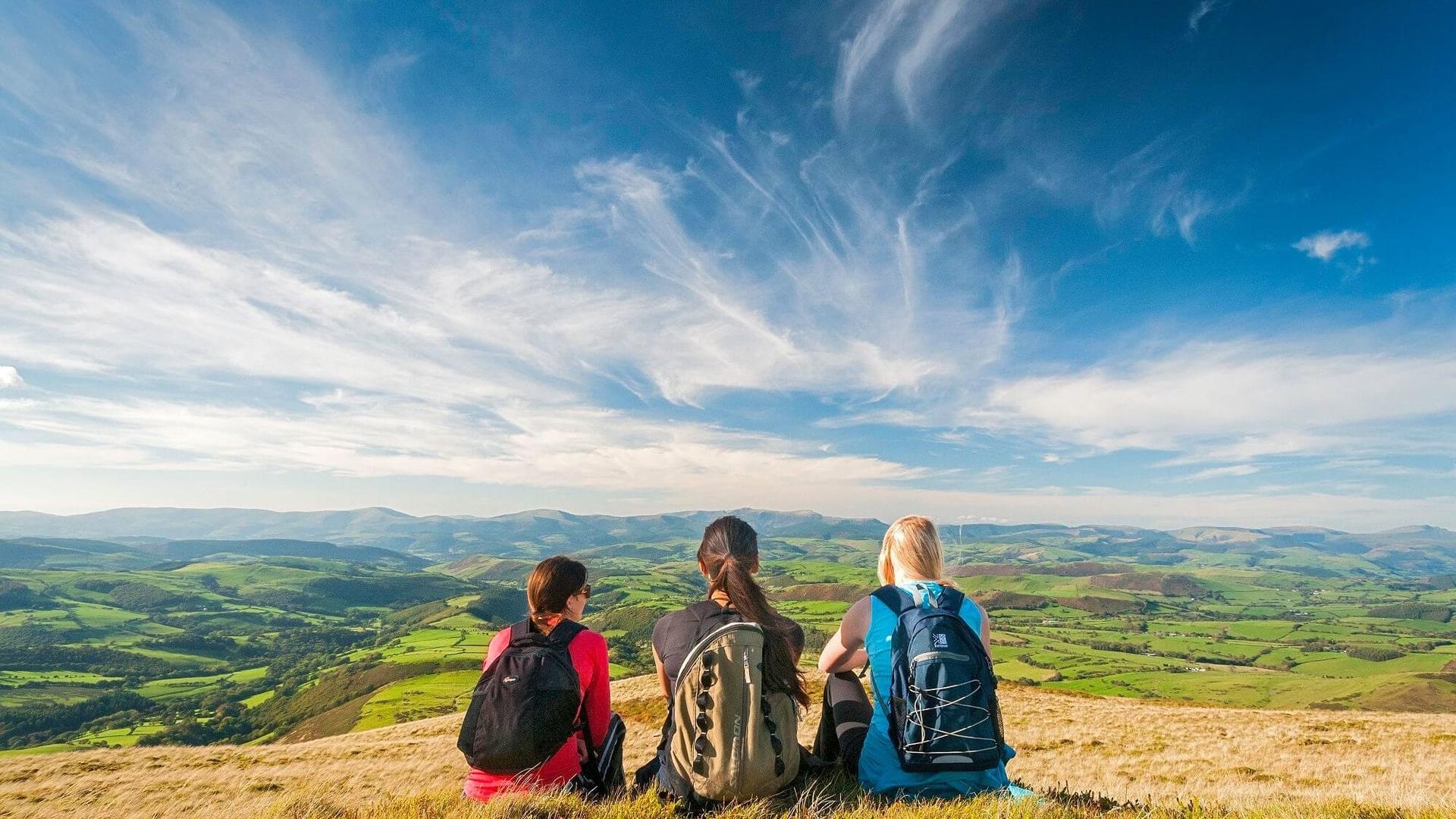 Three walkers enjoying the view from the top of a hill