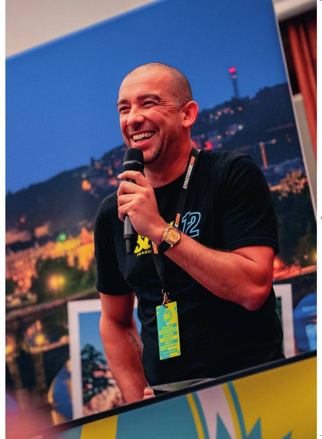 Maurice Hartsuiker speaks into the microphone, smiling, during an event briefing.