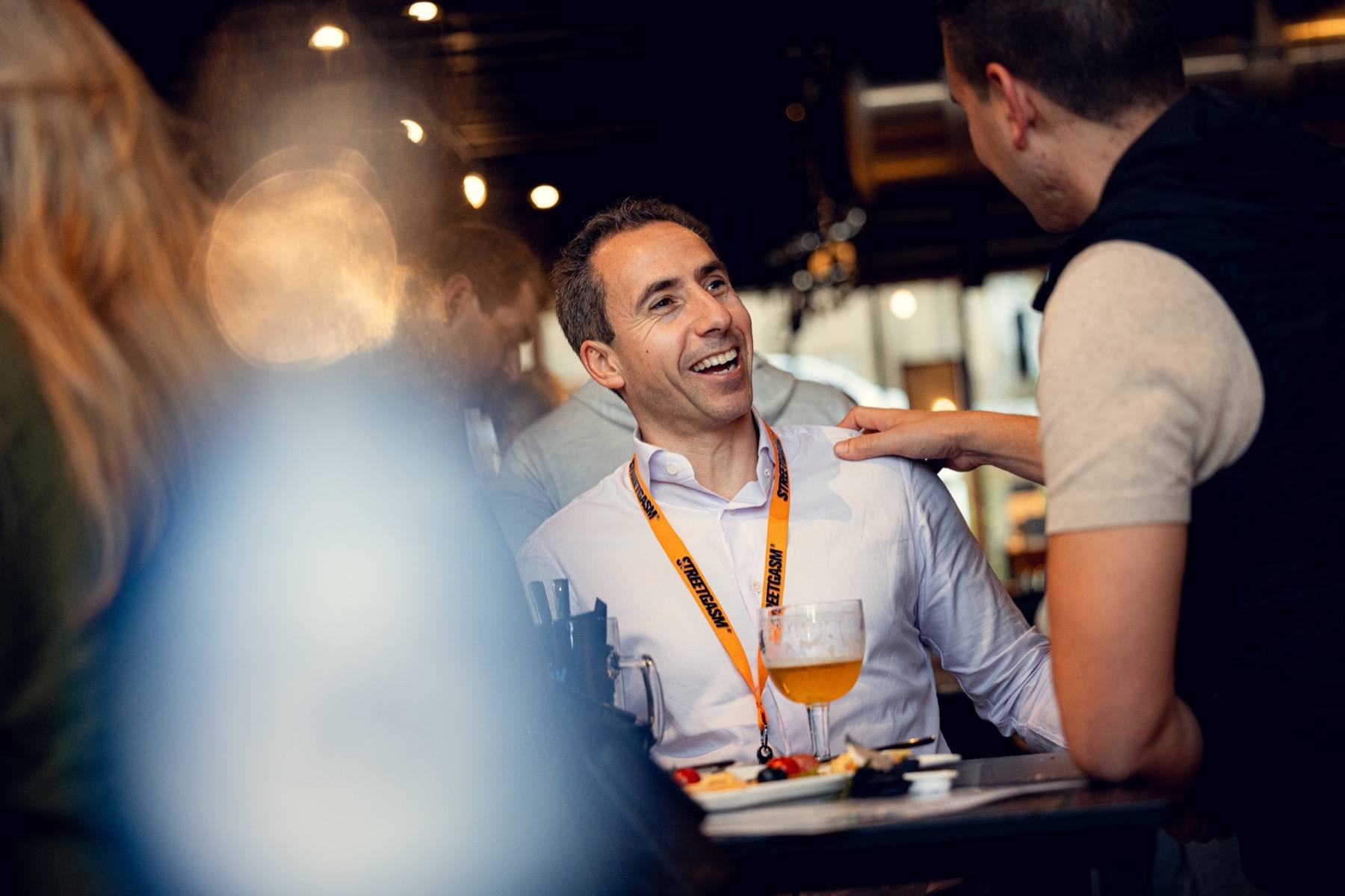 A StreetGasm member wearing a lanyard laughs during a club get-together.
