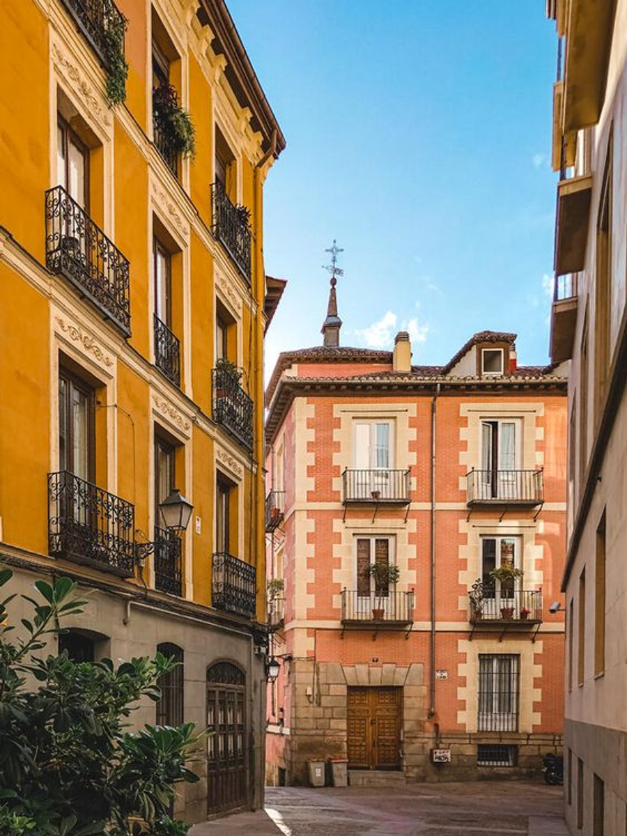 Calle estrecha con edificios coloridos y balcones en una ciudad histórica.