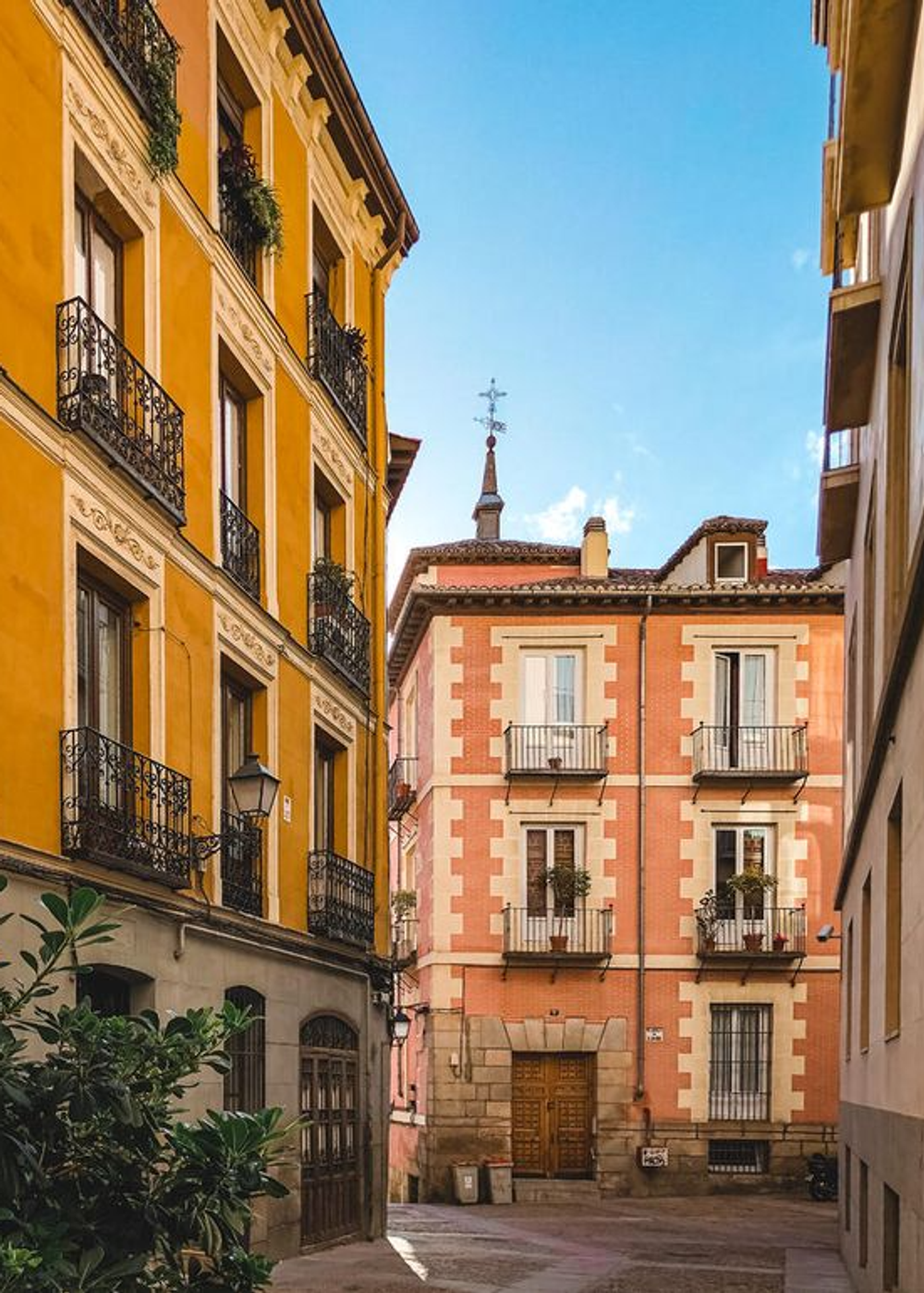Calle estrecha con edificios coloridos y balcones en una ciudad histórica.