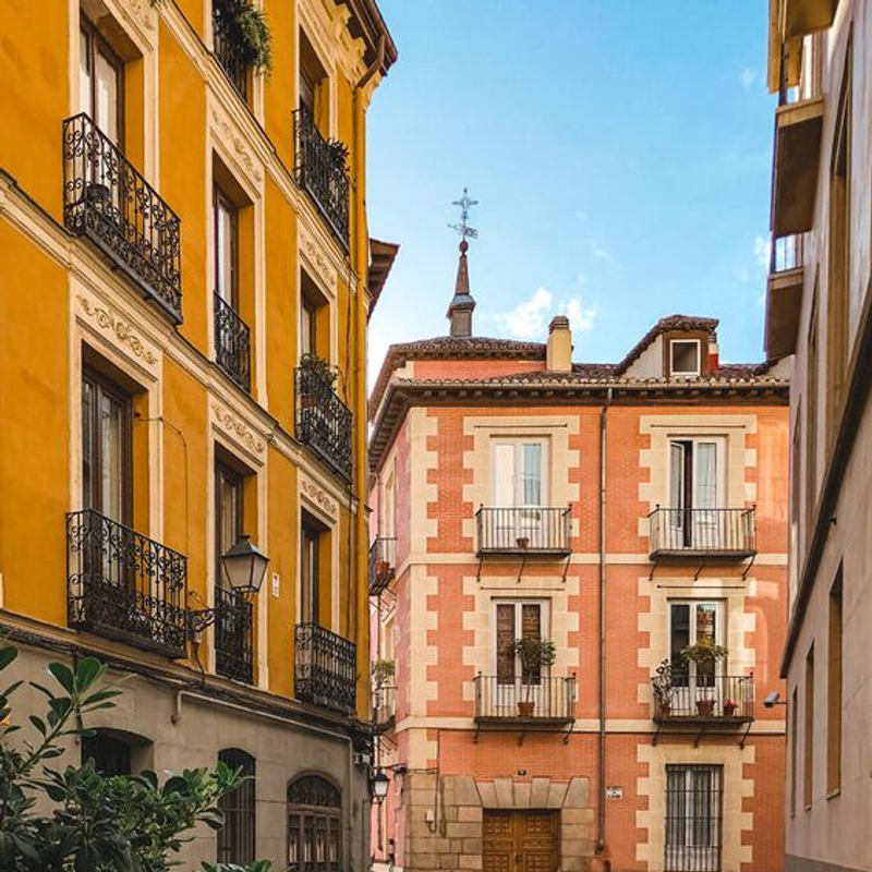 Calle estrecha con edificios coloridos y balcones en una ciudad histórica.