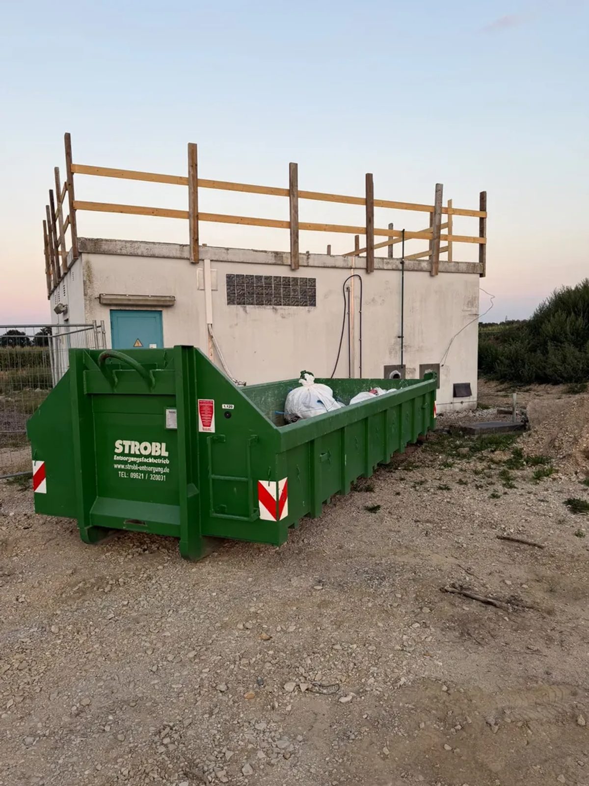 Abrollcontainer mit staubdicht verpackten Big Bags für die Entsorgung asbesthaltiger Dachpappe