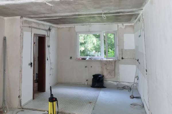 Küche in Wiesbaden nach dem Ausbau der Bodenfliesen: freigelegtes Kleberbett des asbesthaltigen Fliesenklebers auf dem Estrich