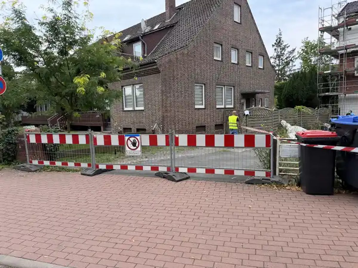 Abgesperrter Arbeitsbereich mit Warnzeichen Asbestfasern vor dem Wohnhaus an der Lange Straße in Hessisch Oldendorf